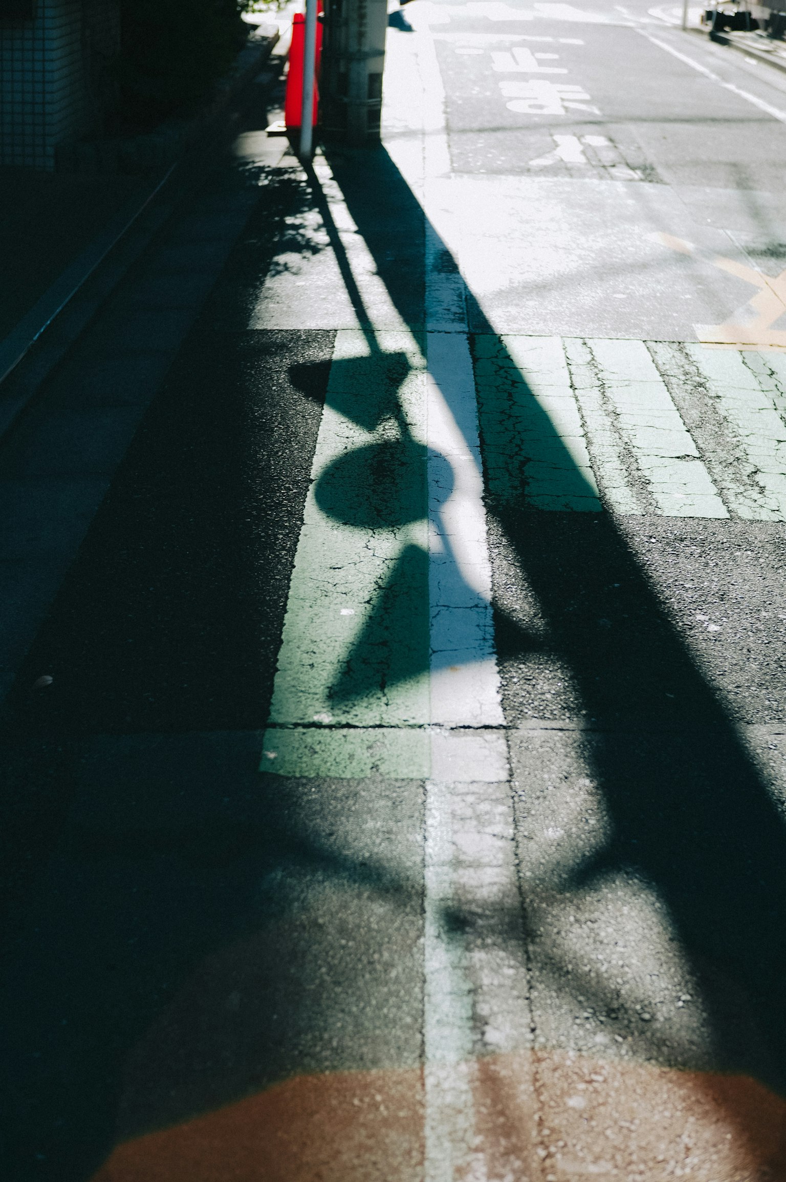 影が交差する街の風景 緑の線と交通標識の影