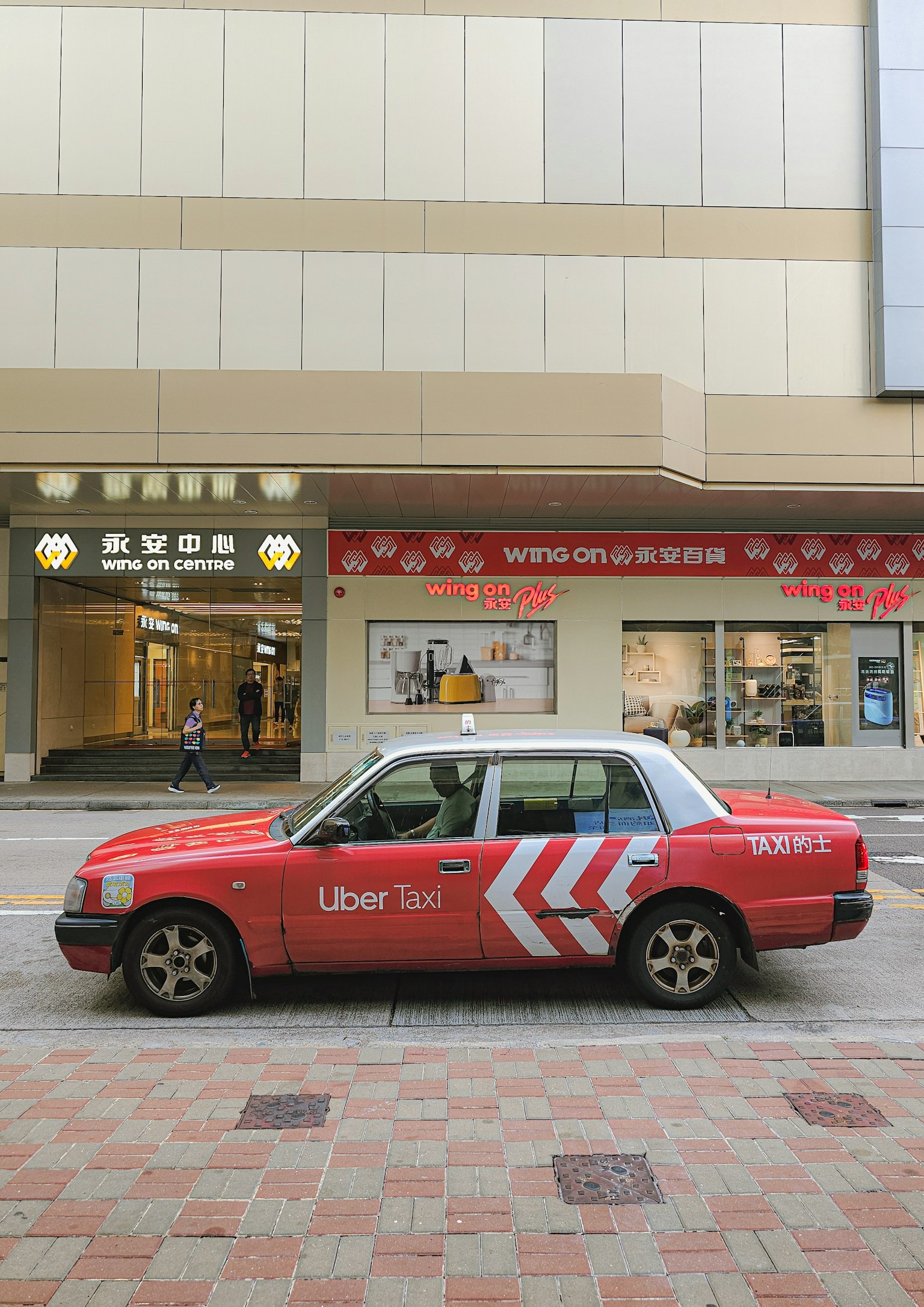 停在街上的紅色計程車和背景的商店