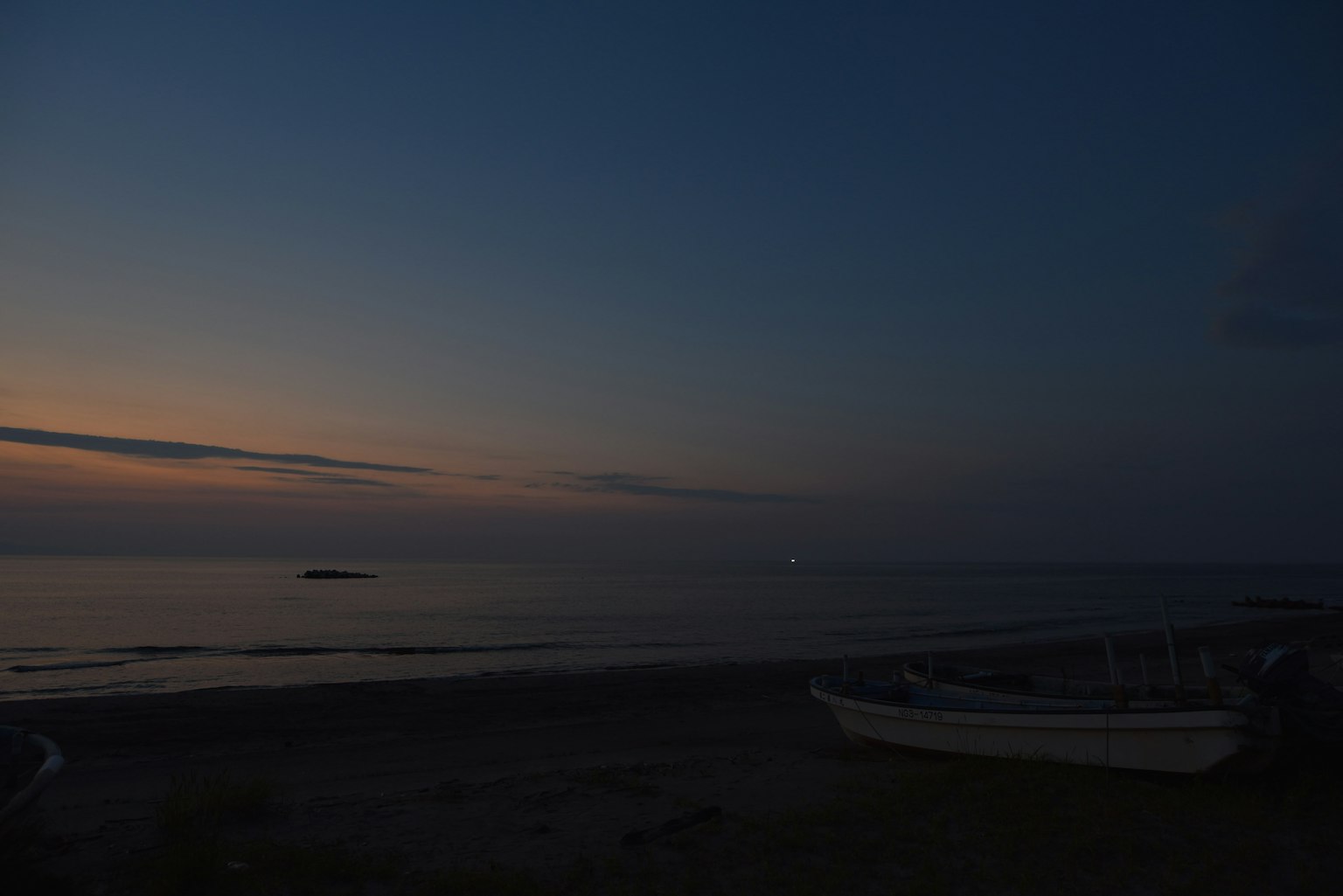黄昏海岸景观与宁静海面和远处灯光