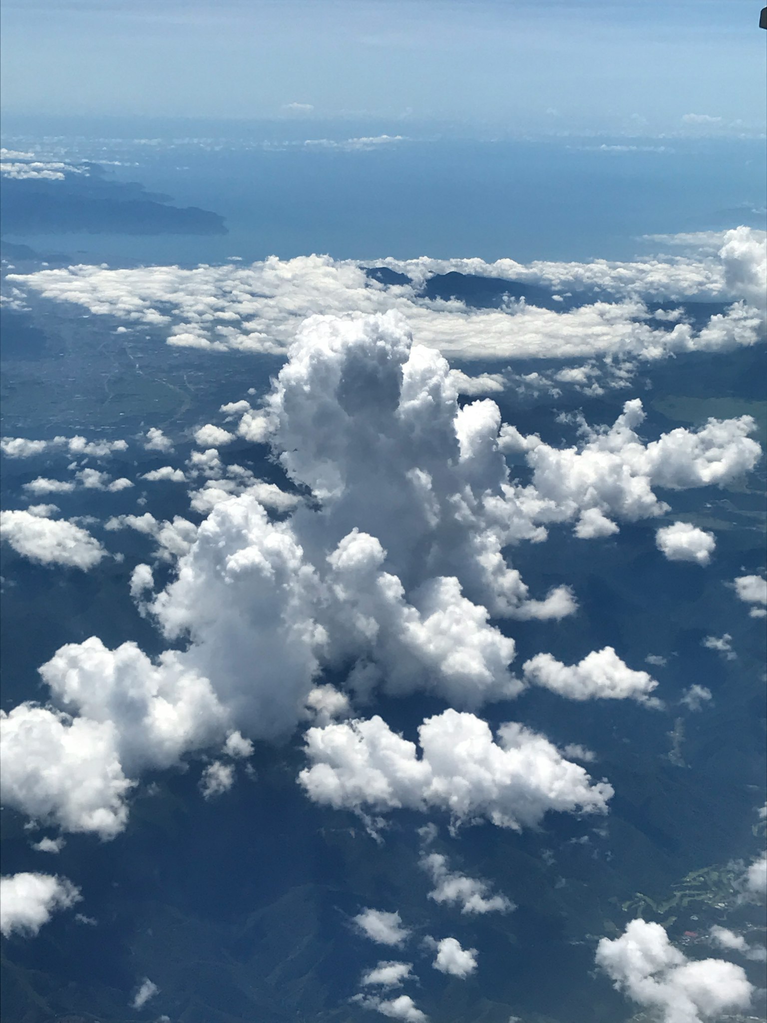 海洋和山脉上方的蓬松云彩的空中视图