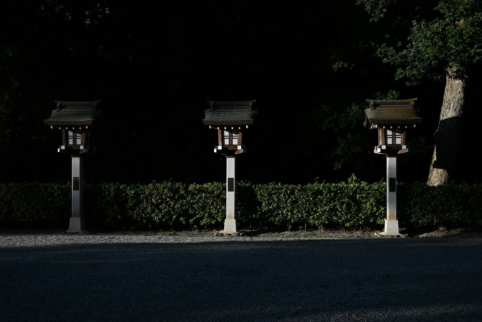 Three lanterns standing against a dark background