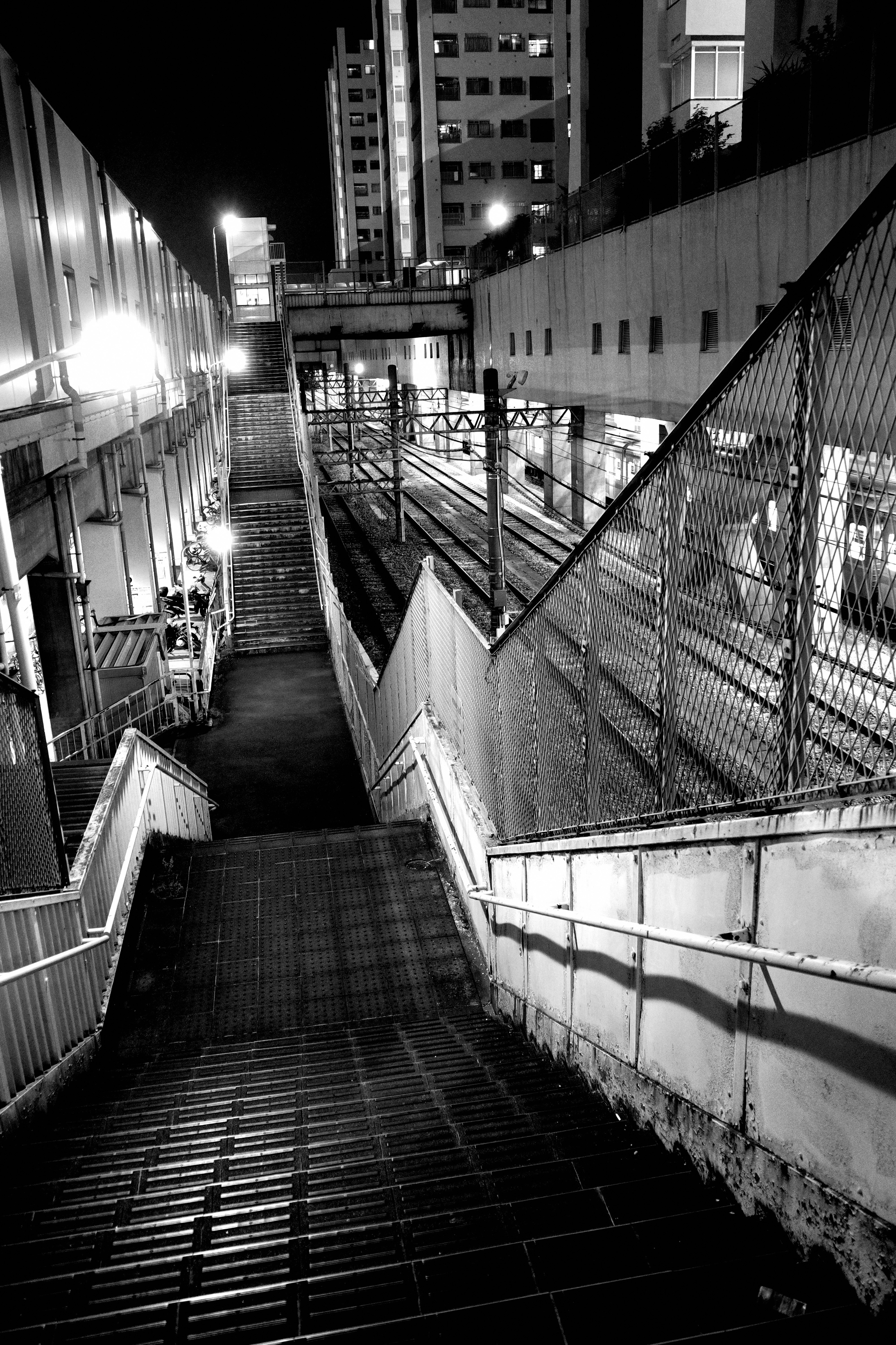 escaliers et passerelles la nuit entre des immeubles de grande hauteur