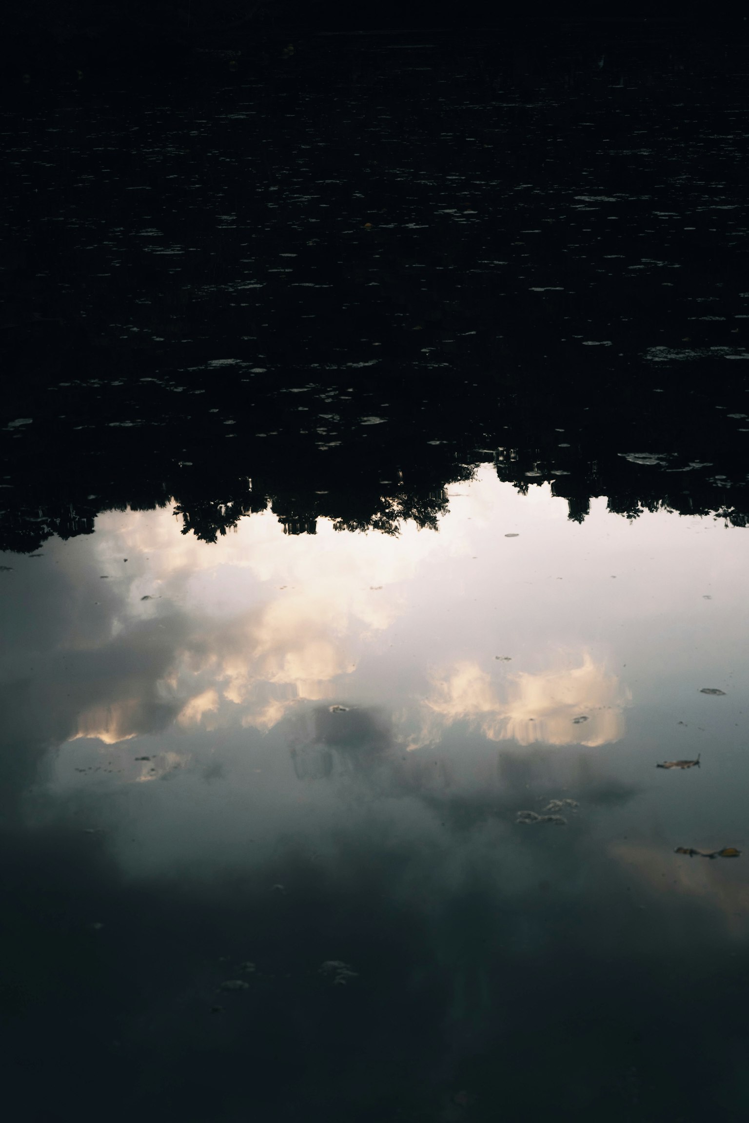 Refleksi awan di permukaan air gelap
