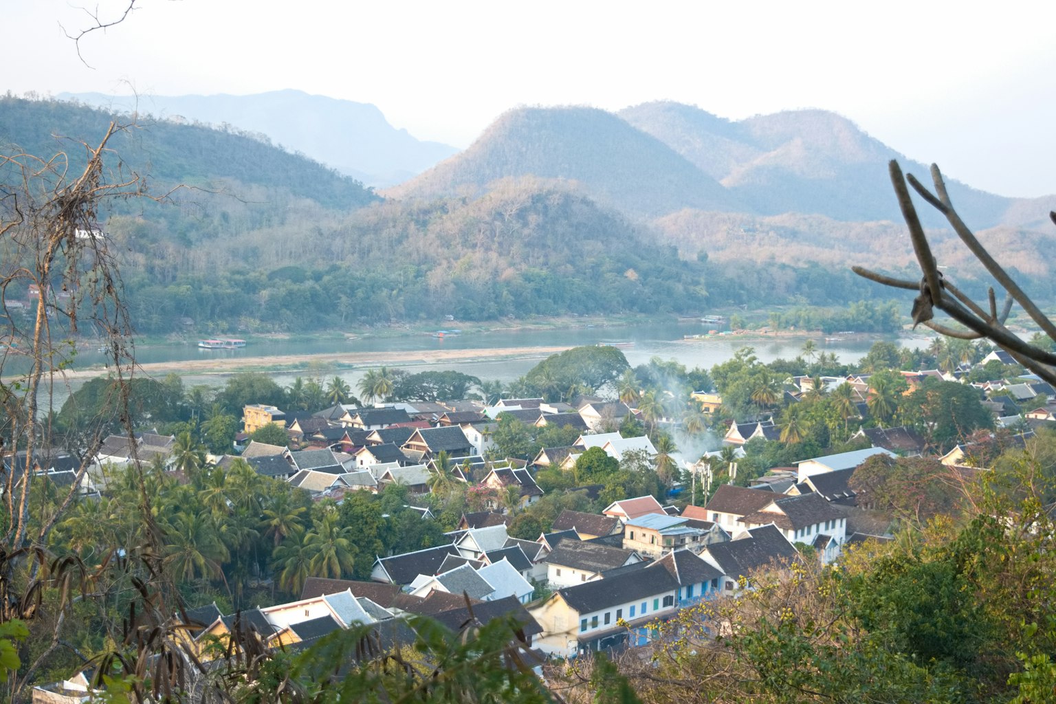 Vista escénica de un pueblo rodeado de montañas cerca de un río