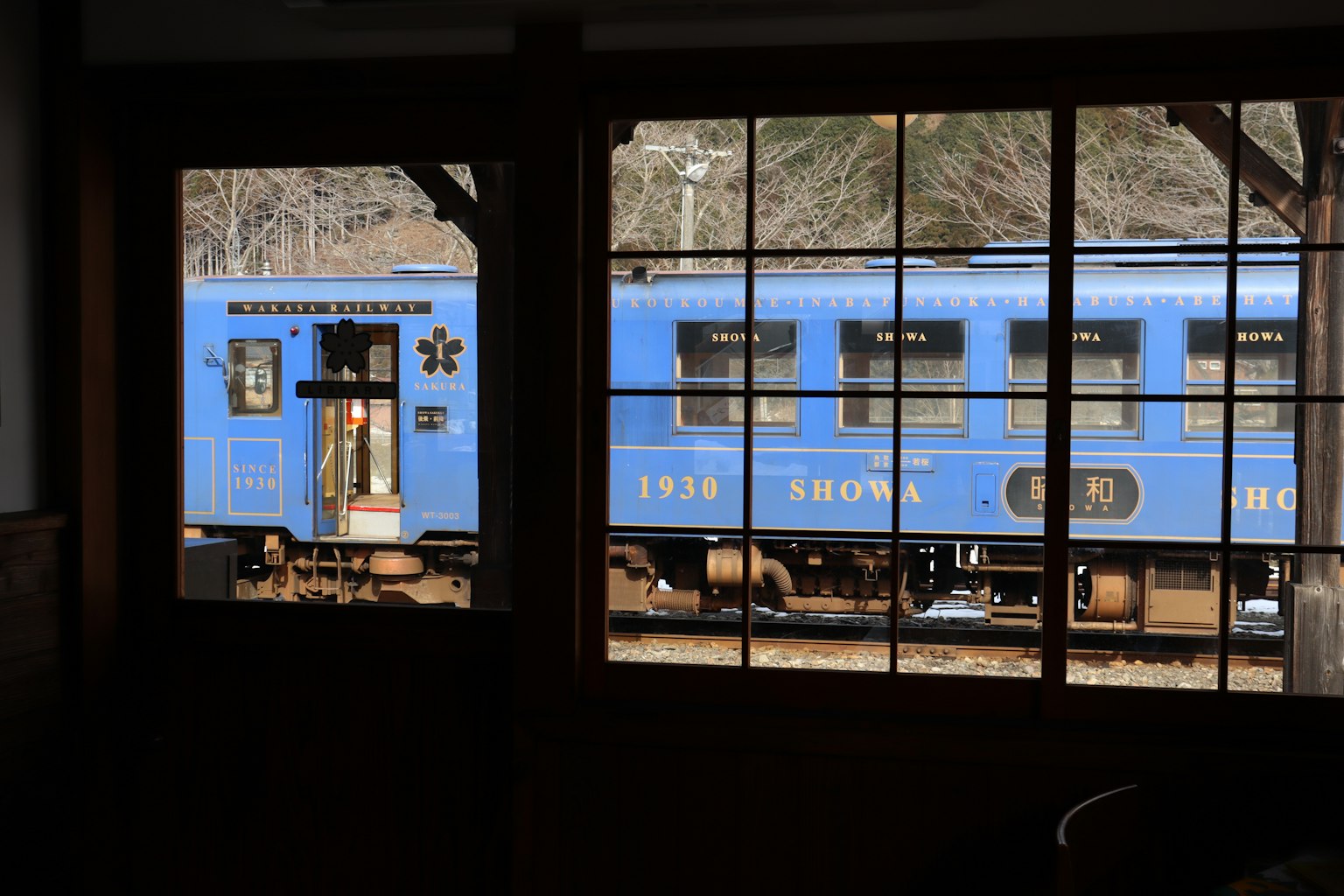 A blue train visible through a window
