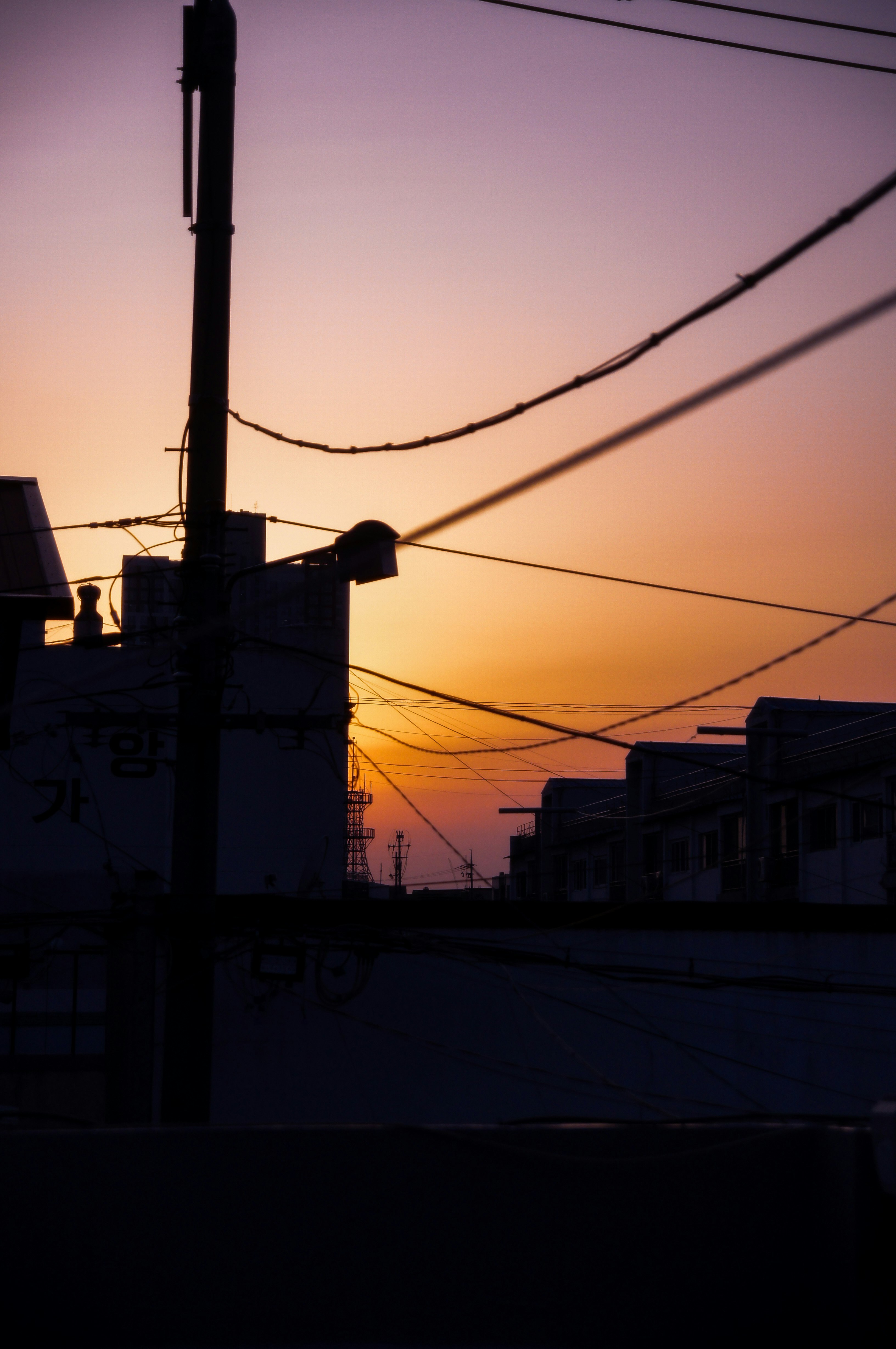 夕焼けの空に電線と街並みがシルエットの夕景