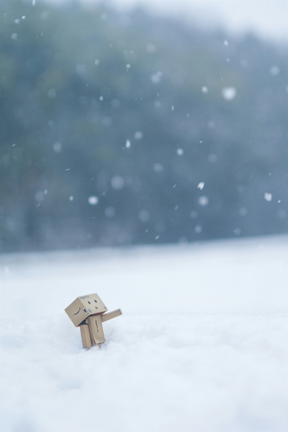 雪の中に佇む小さな木製人形