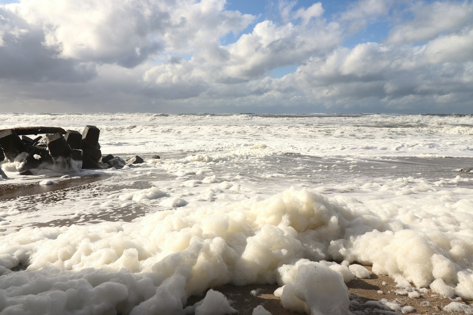 Laut bergelora dengan busa putih di pantai