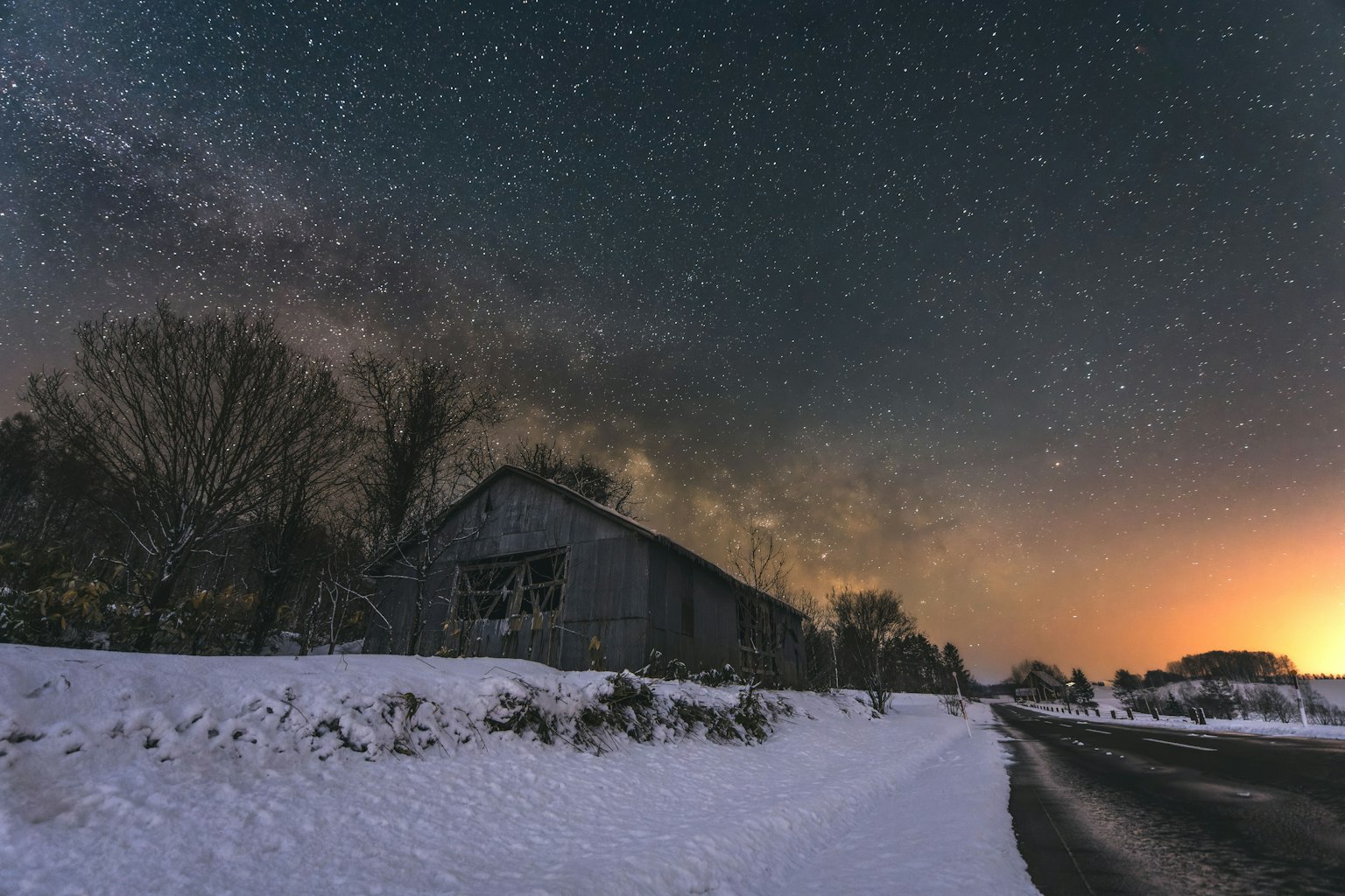 Paysage enneigé avec un bâtiment sous un ciel étoilé