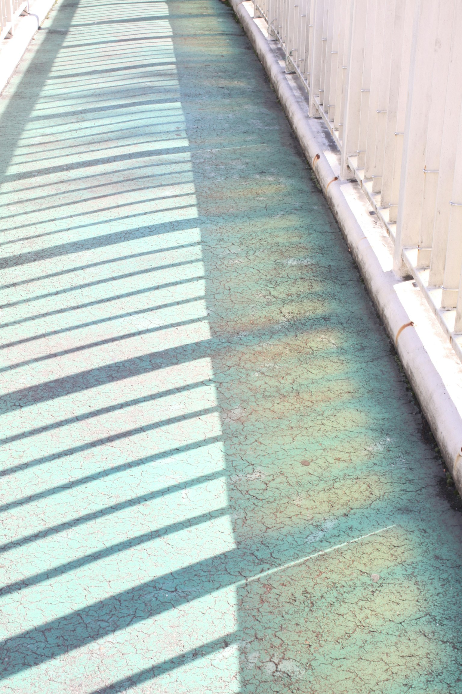 Un chemin turquoise avec des ombres projetées sur la surface