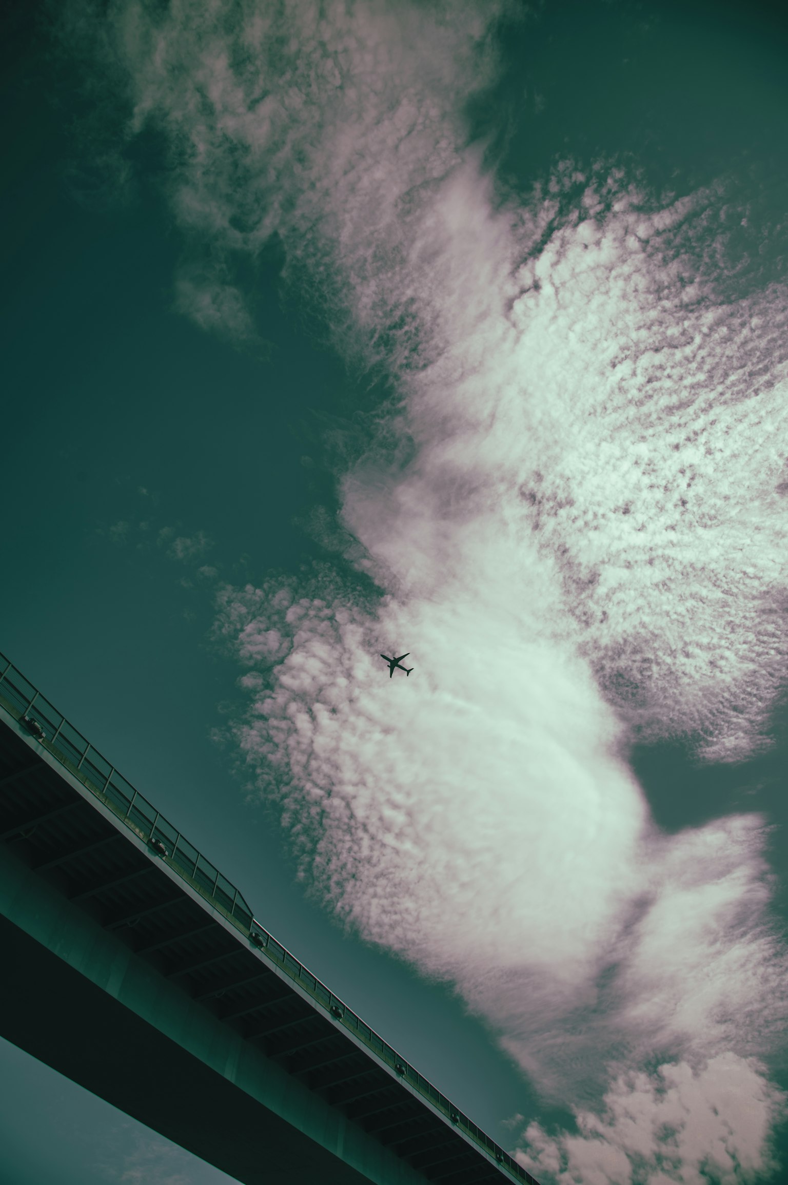 Eine Sicht auf weiße Wolken vor einem blauen Himmel mit einer Brücke darunter