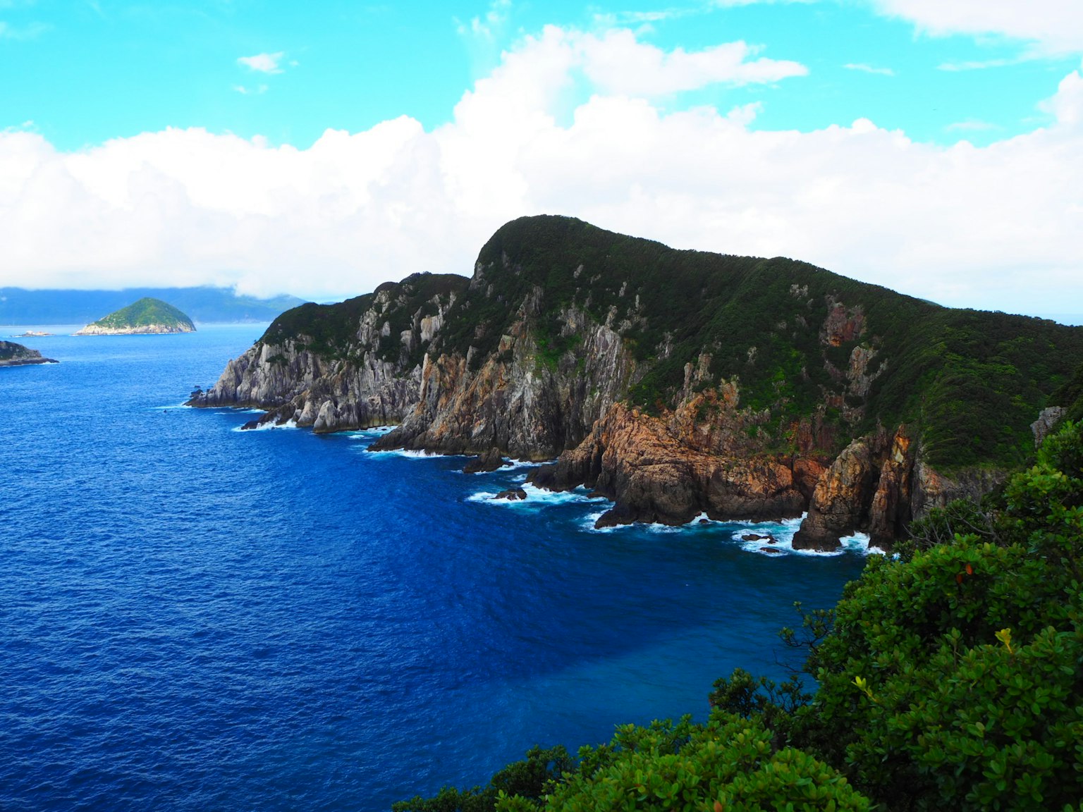 Paesaggio costiero con scogliere rocciose e oceano blu vibrante