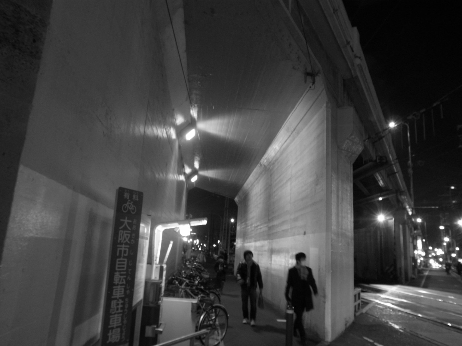 Deux personnes marchant dans une ville la nuit avec des lampadaires lumineux