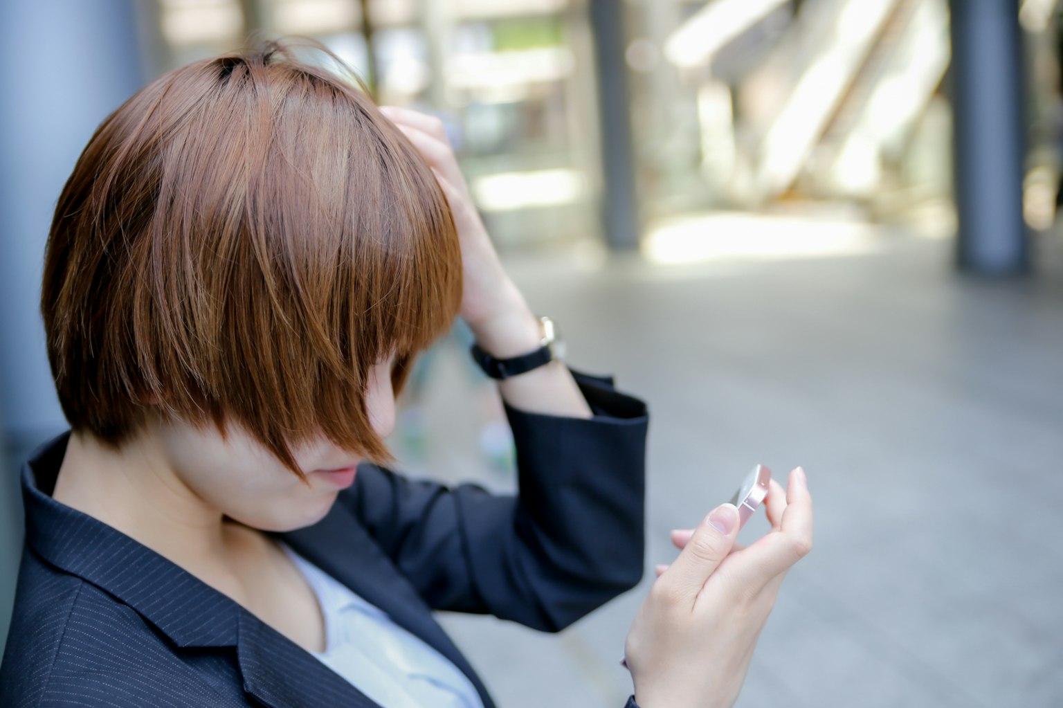 Người phụ nữ tóc ngắn màu nâu đang nhìn vào điện thoại thông minh