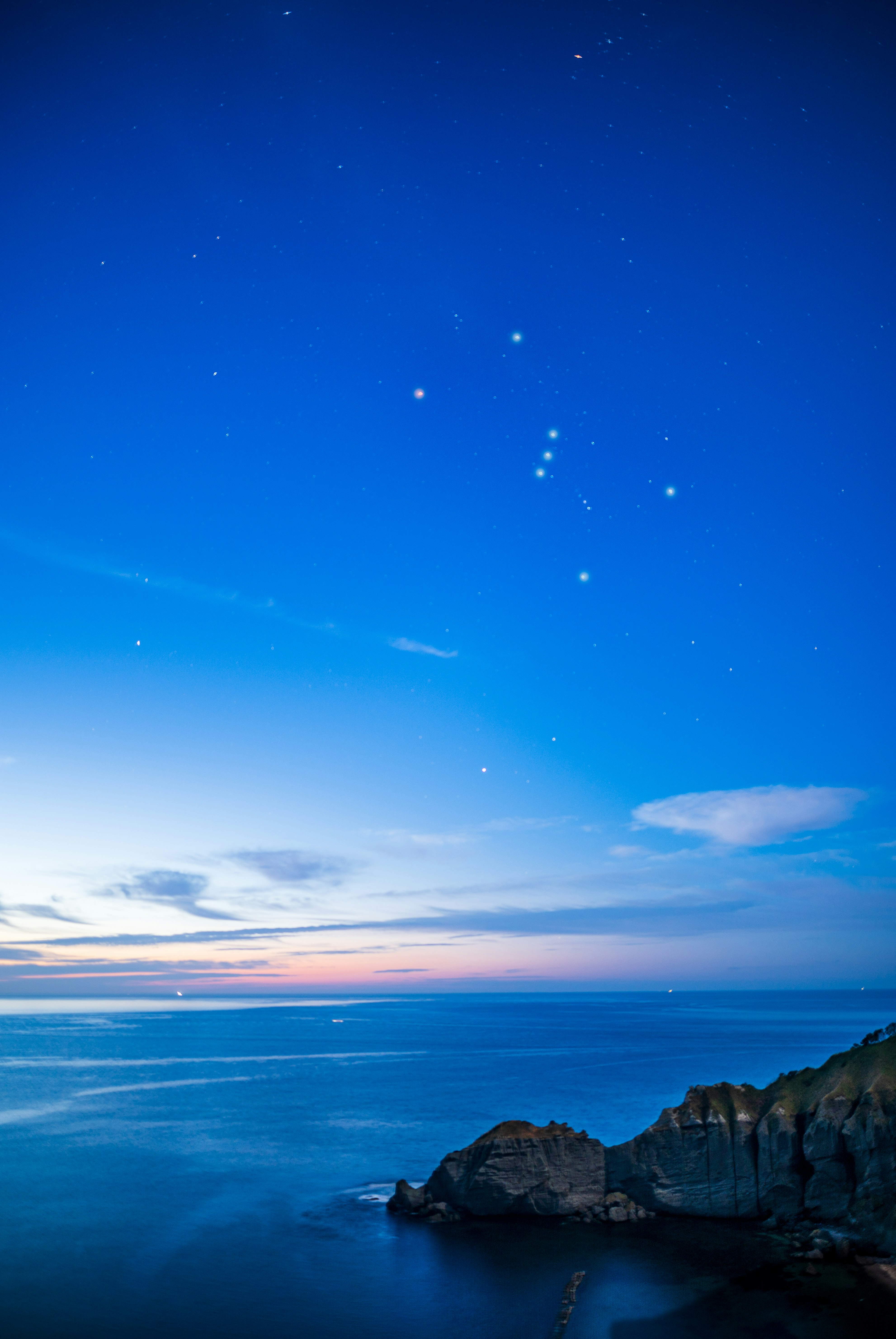 青い空と海に沈む夕暮れの海岸線
