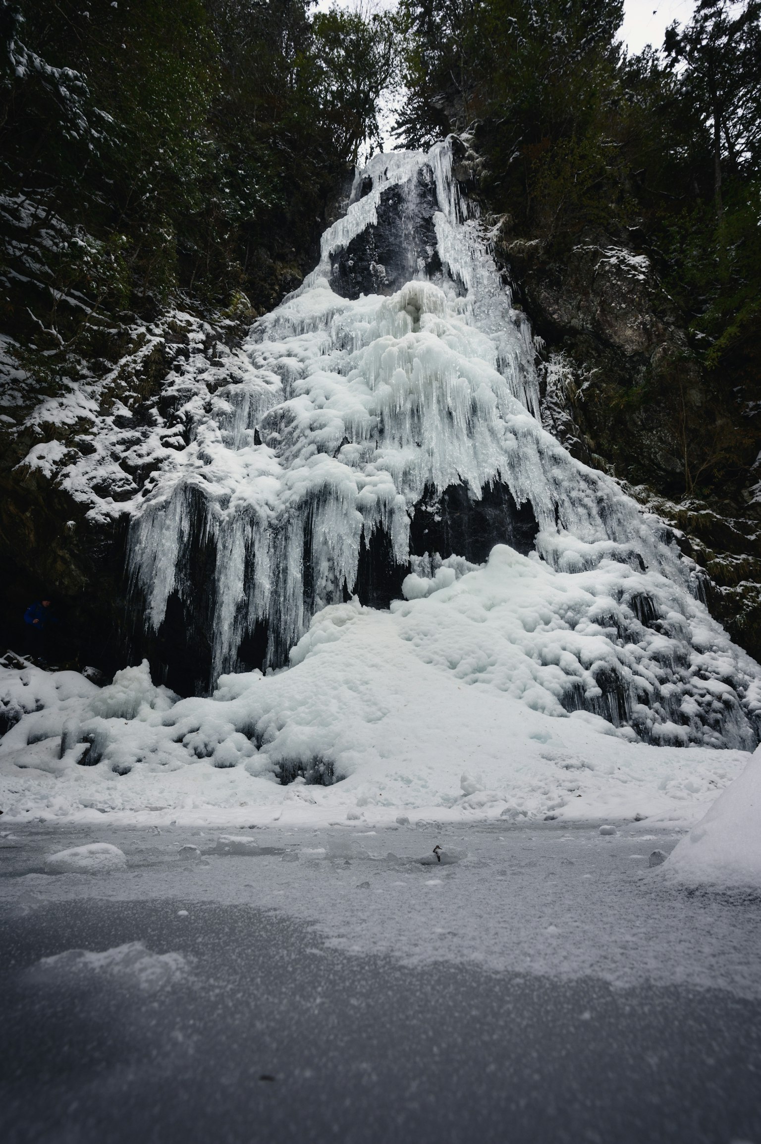 Cascada congelada rodeada de nieve y hielo