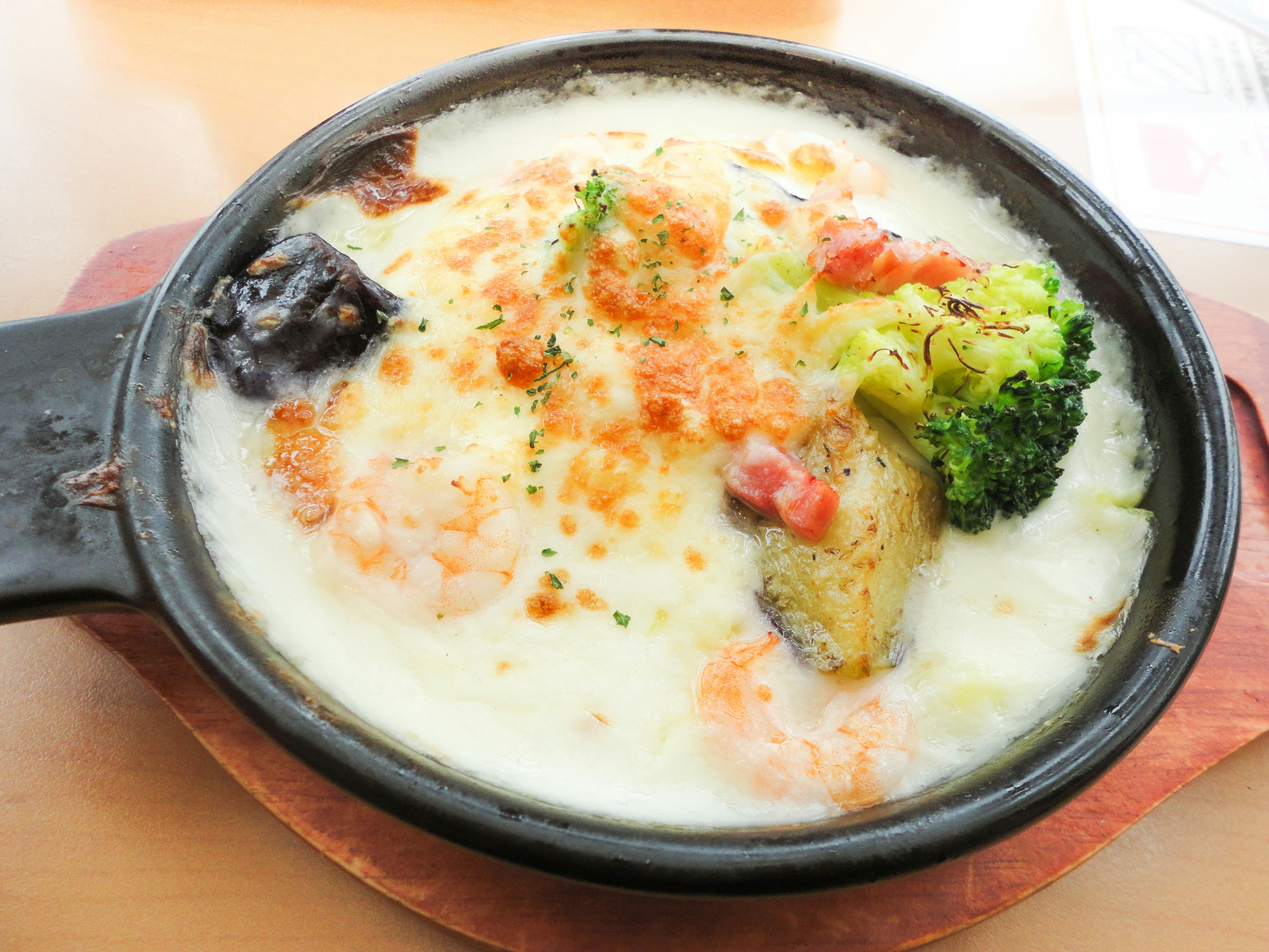 熱々のチーズと野菜がトッピングされたグラタン