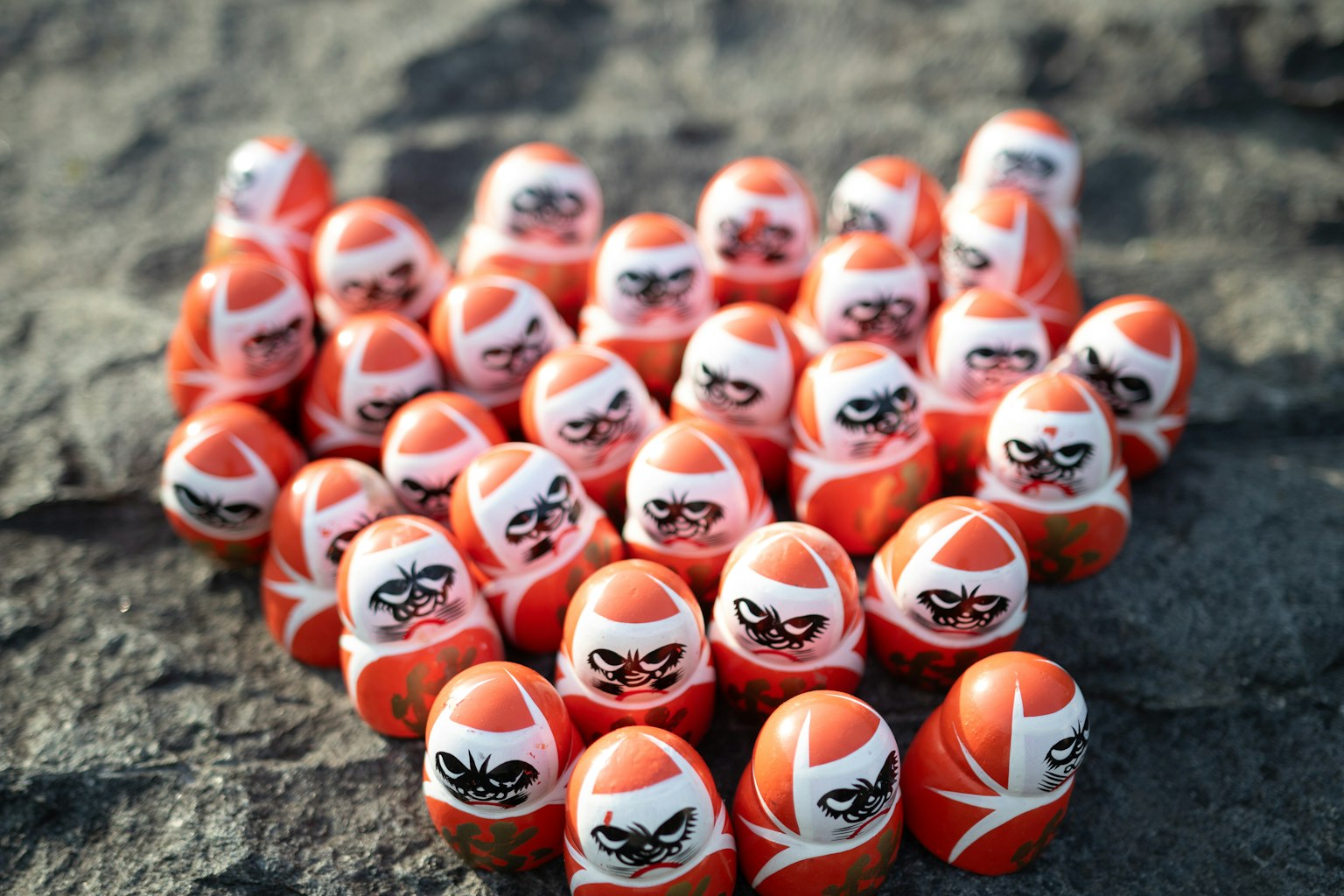 Une collection de poupées russes ninja rouges disposées sur une surface rocheuse