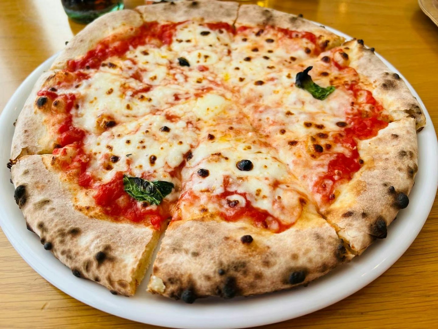 Pizza Margherita appena sfornata su un piatto bianco