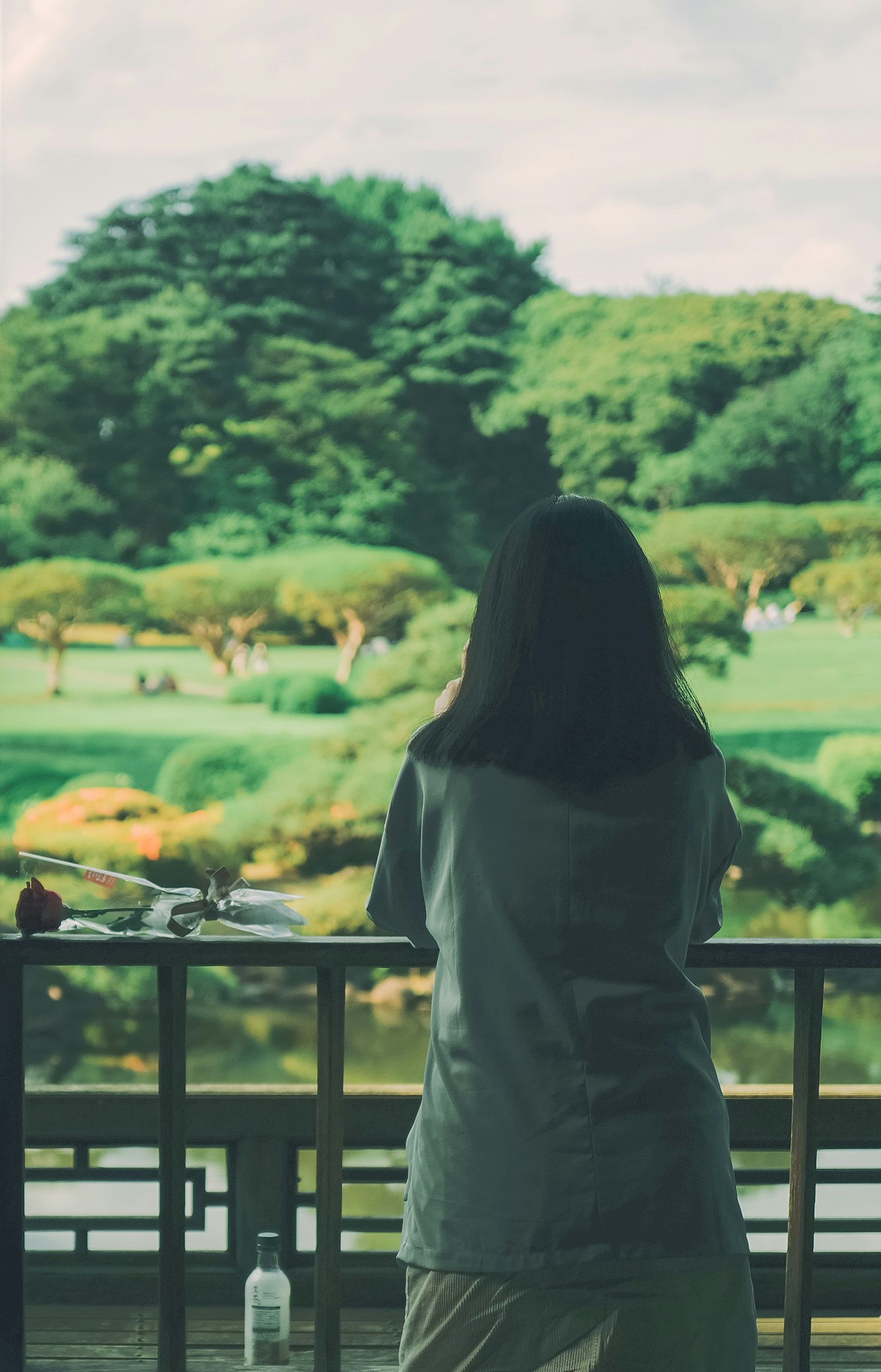 Woman gazing at a lush garden landscape
