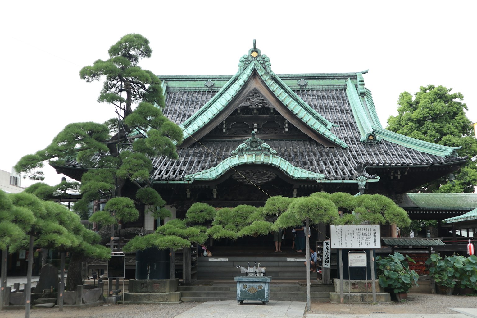 日本寺廟的外觀，綠色屋頂和周圍的樹木