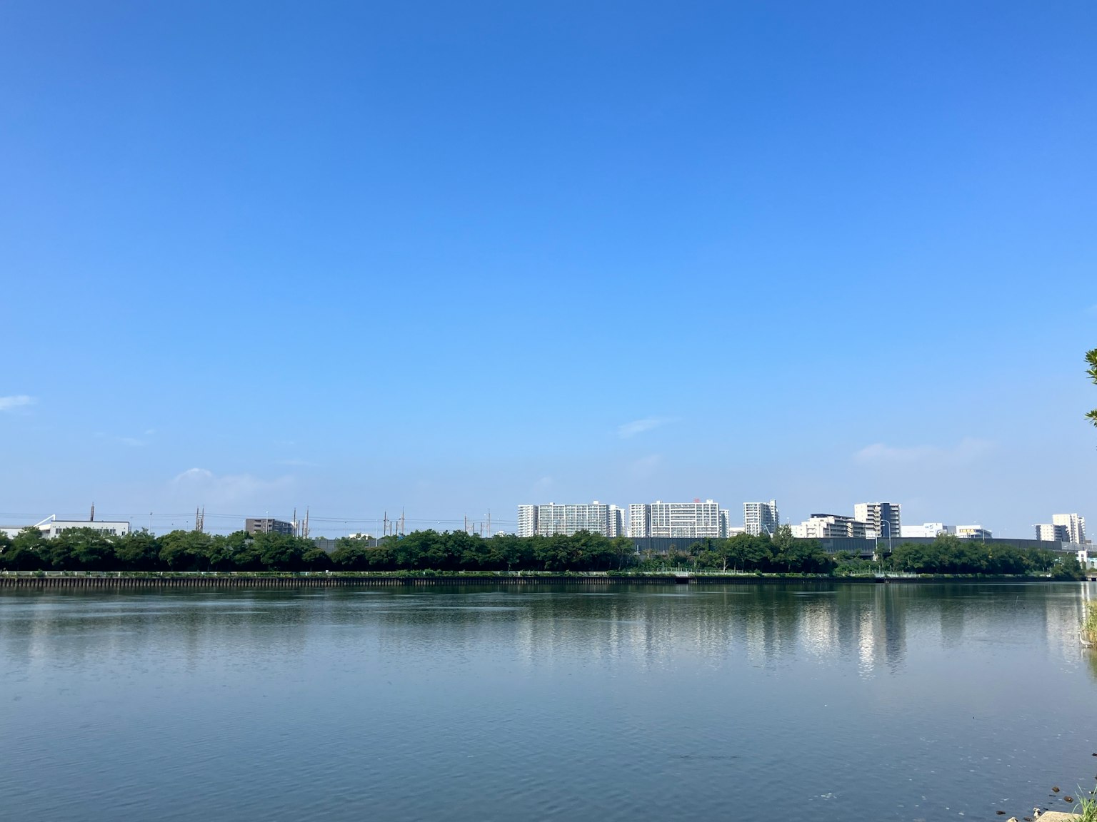 Serene river view reflecting blue sky and surrounding buildings