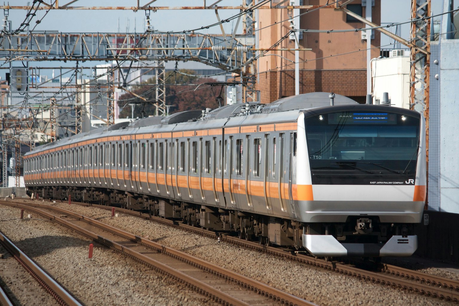 Train orange et argent circulant sur des voies ferrées