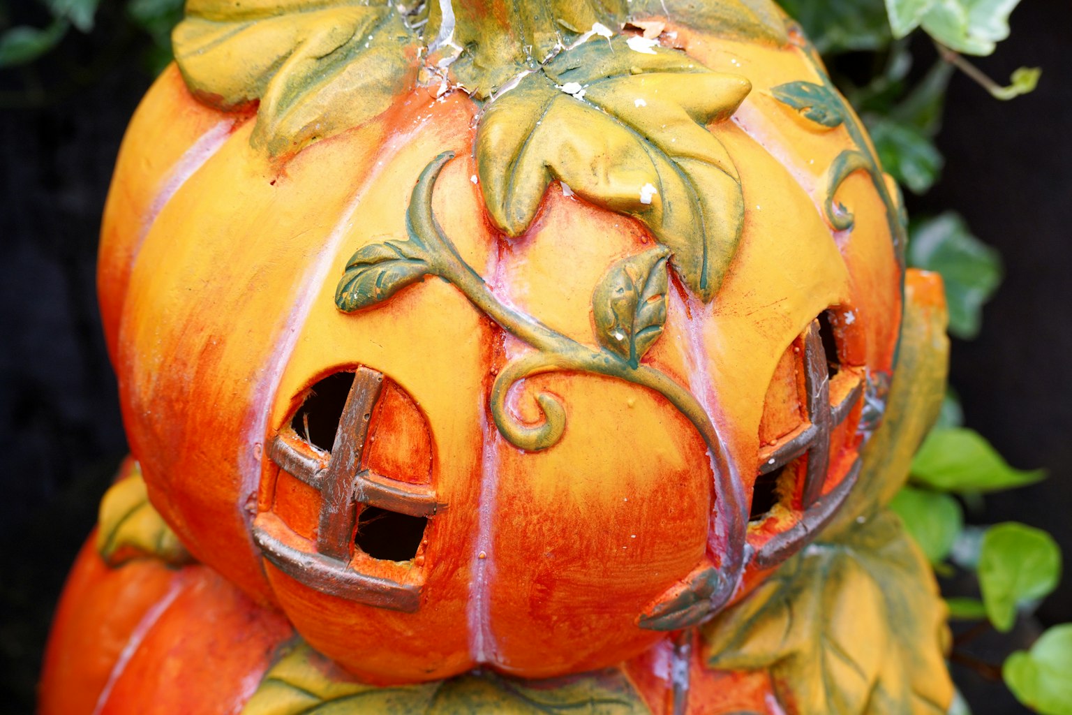 Zucca decorativa arancione con piccole finestre e motivi di foglie