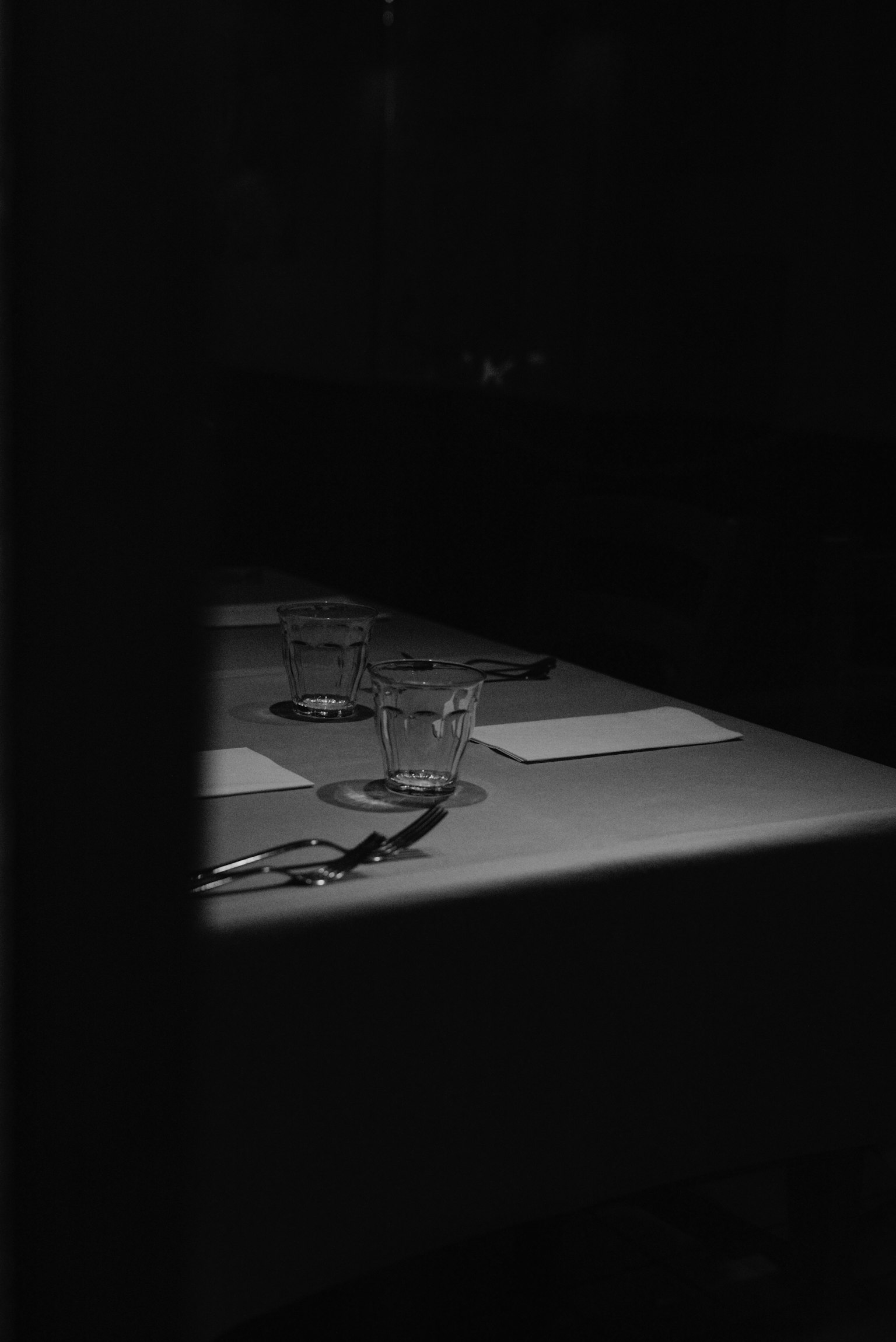 Tavolo di ristorante debolmente illuminato con coltello e forchetta disposti elegantemente