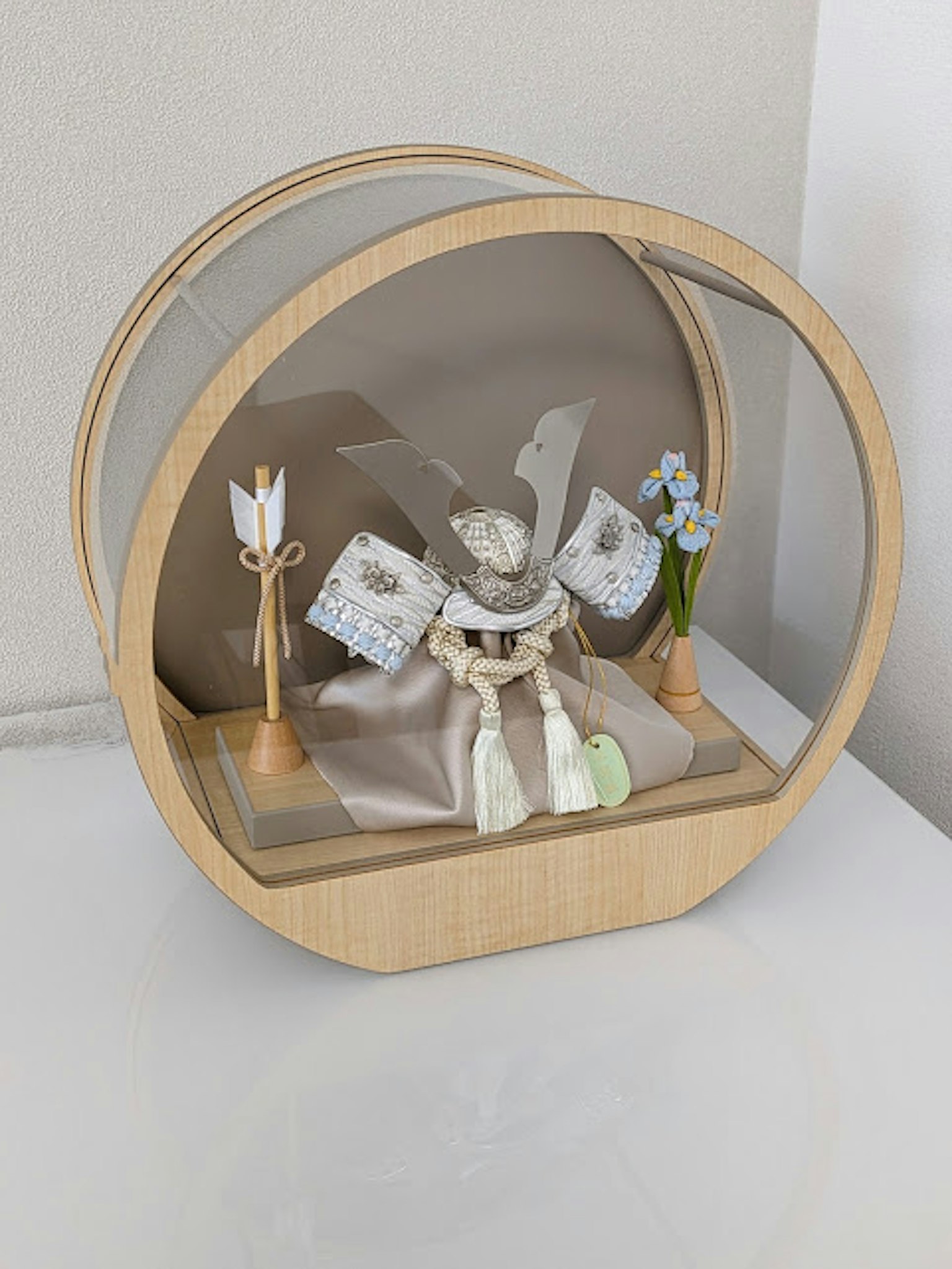 Figurina decorativa esposta con fiori all'interno di una teca in legno