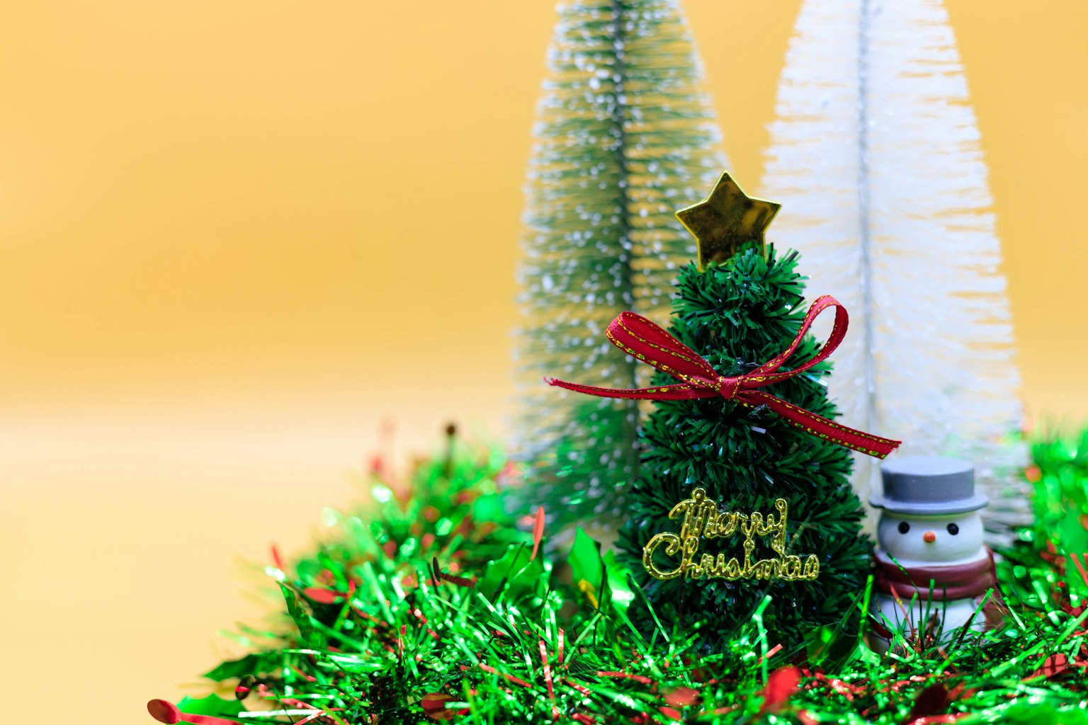 Decoraciones navideñas con un pequeño árbol y un muñeco de nieve