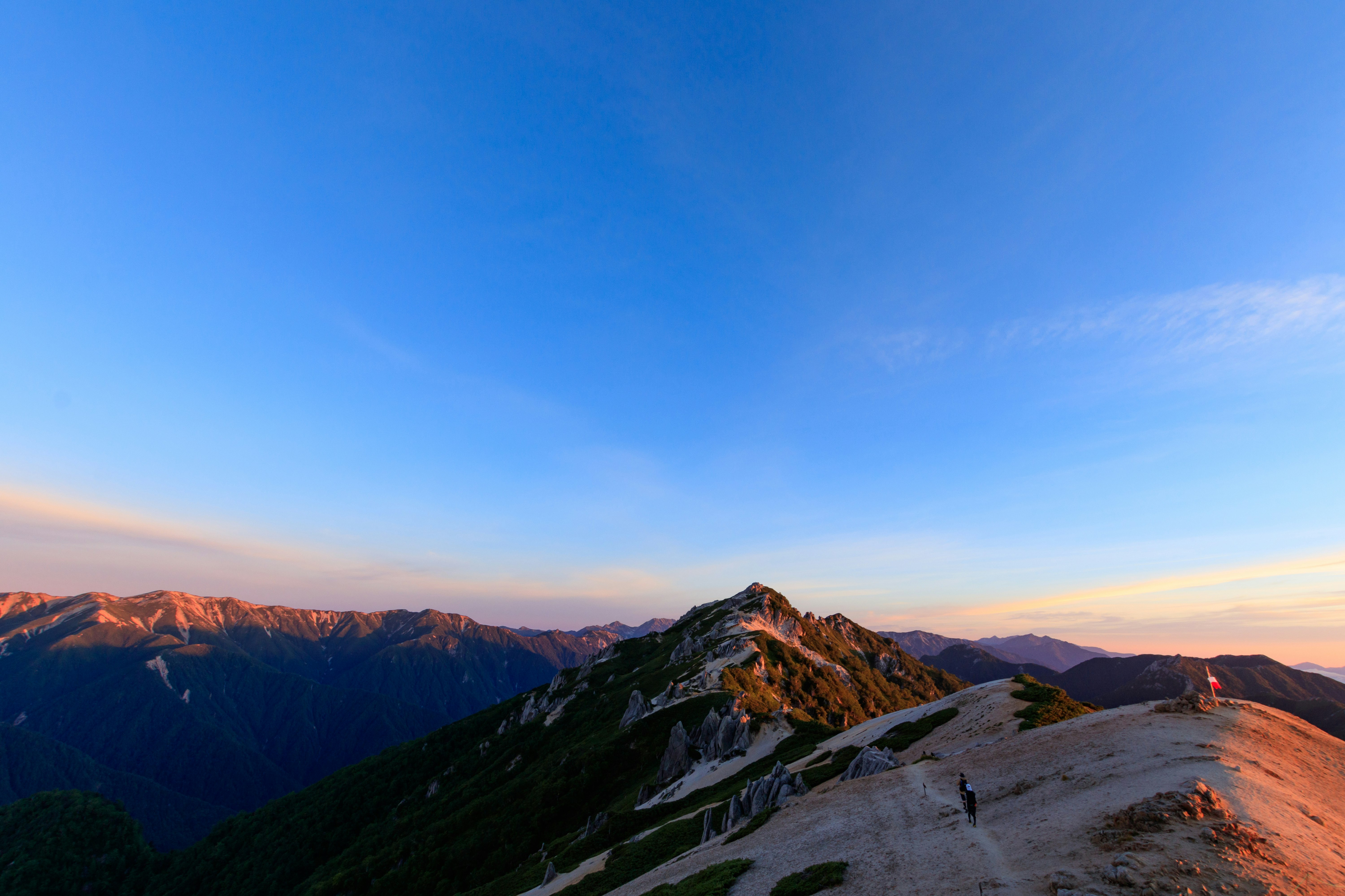 randonneurs sur une crête de montagne au coucher du soleil