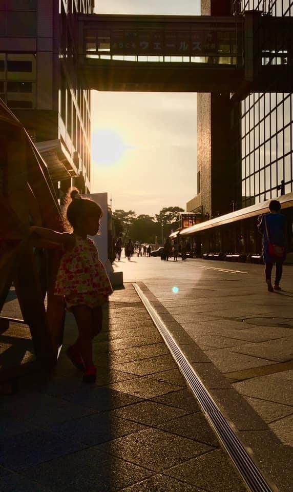 people walking along an elevated walkway at sunset