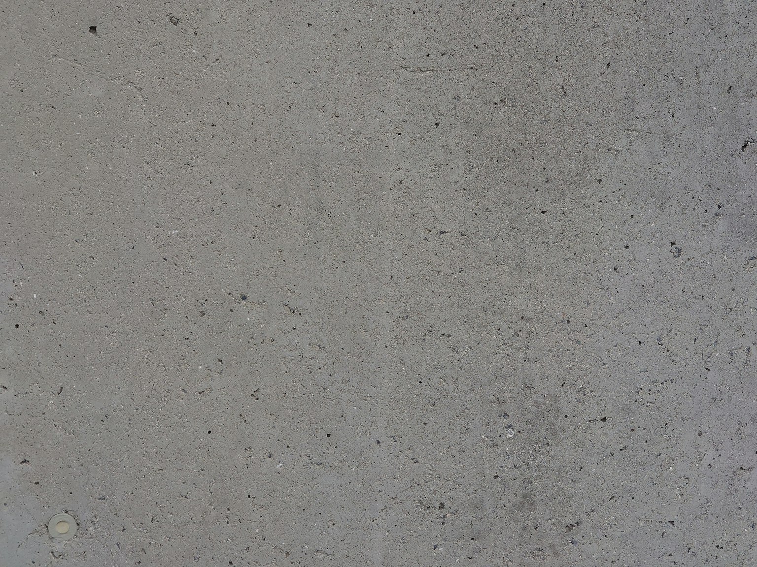 Primo piano di una texture di cemento con una superficie grigia chiara e particelle fini