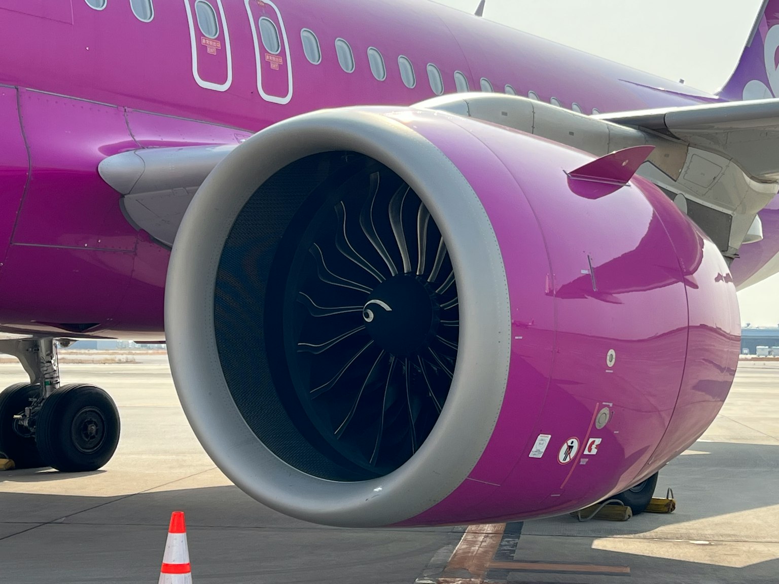 Nahaufnahme eines lila Flugzeugmotors mit sichtbaren Turbinenblättern