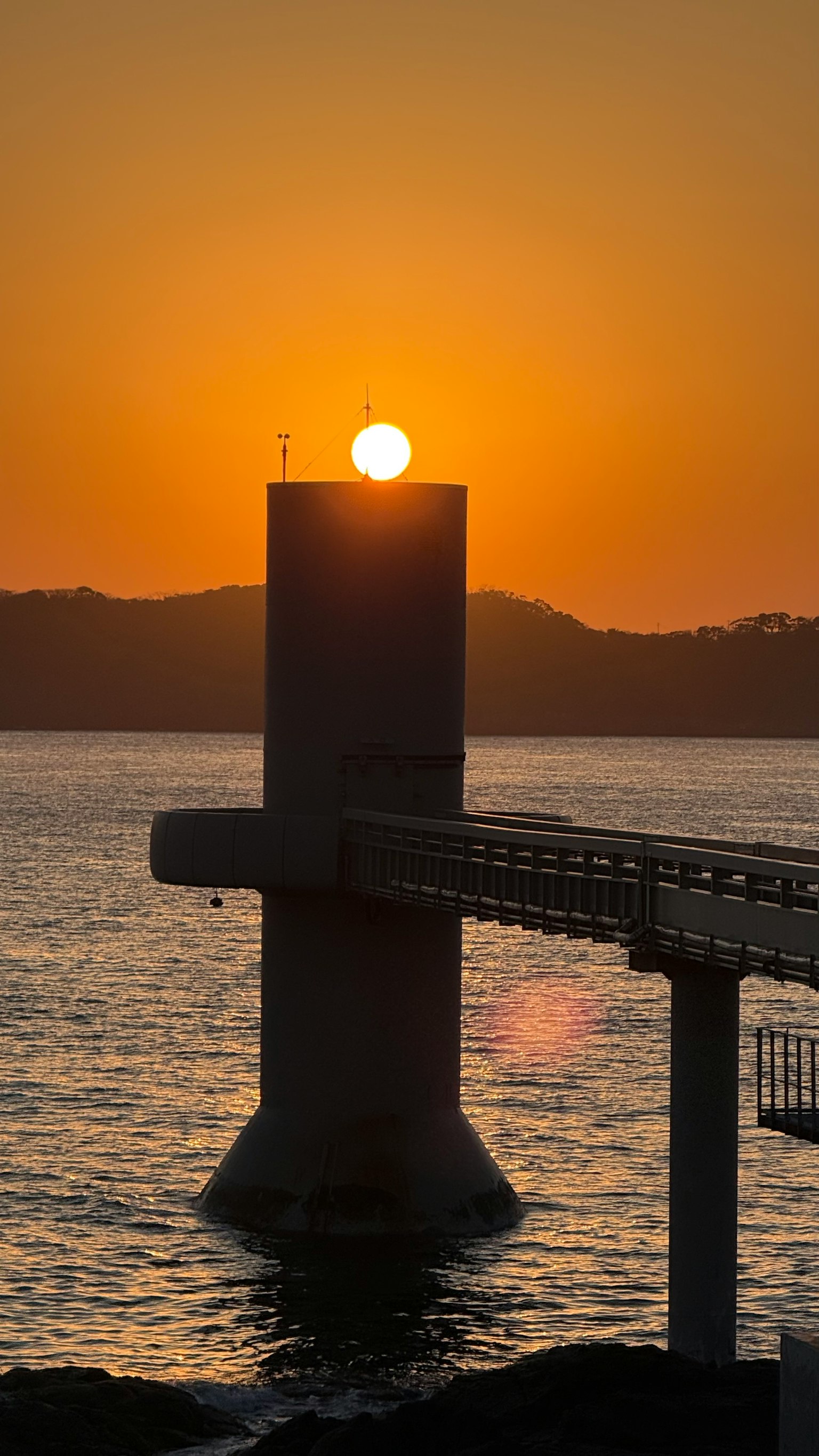Une structure de quai avec le soleil se levant derrière