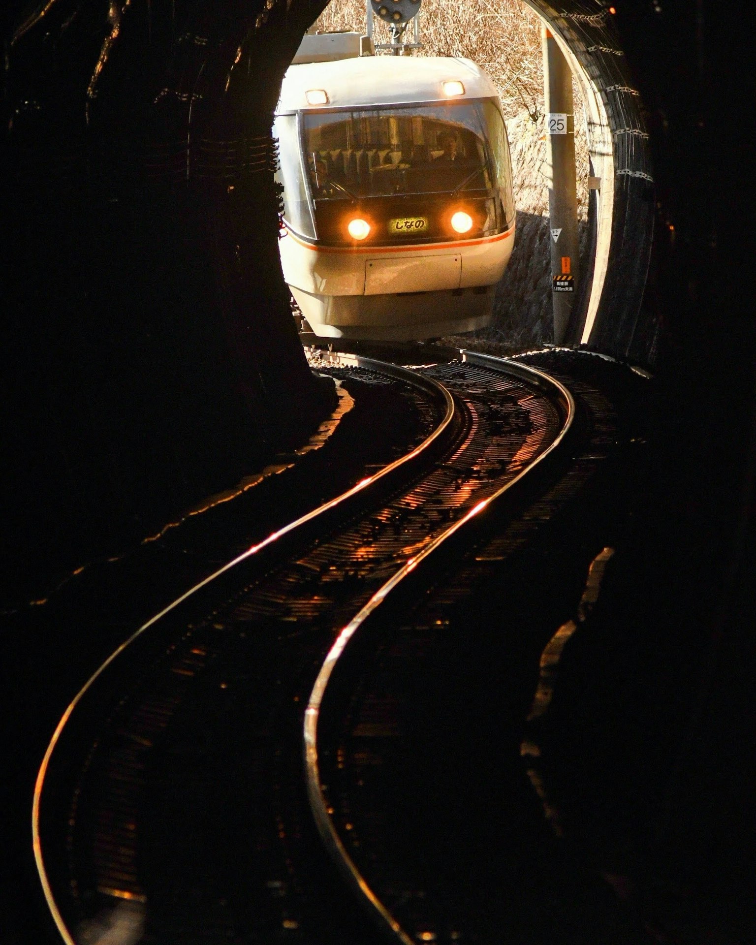 Image d'un train émergeant d'un tunnel avec des phares brillants