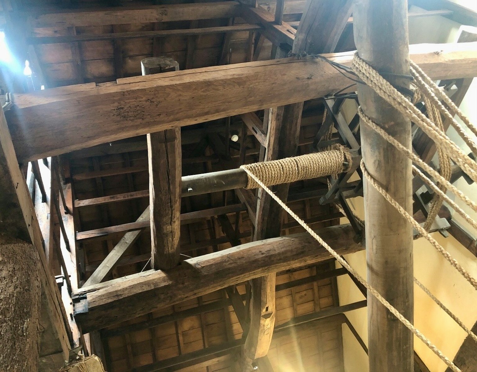 Interior of a traditional building with wooden beams and visible ropes