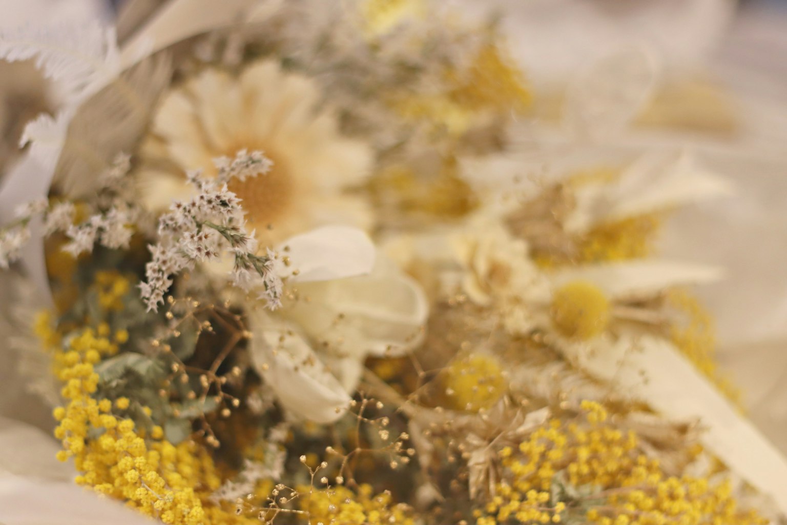 Gros plan sur un bouquet avec des fleurs jaunes et des plantes séchées