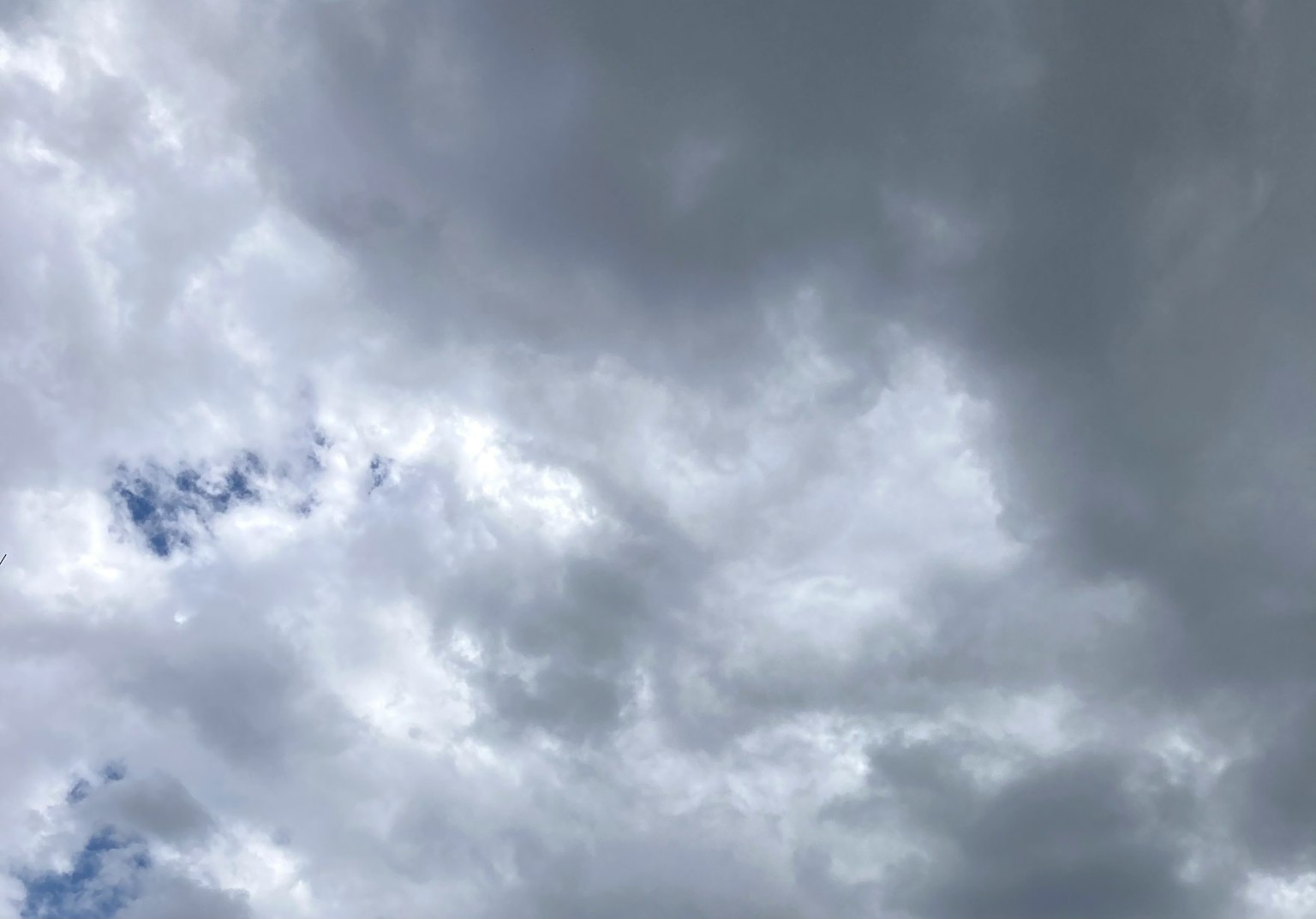 Awan abu-abu menyebar di langit dengan sedikit biru