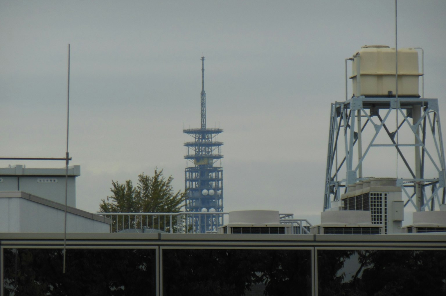 View of a blue tower with rooftops and water tank