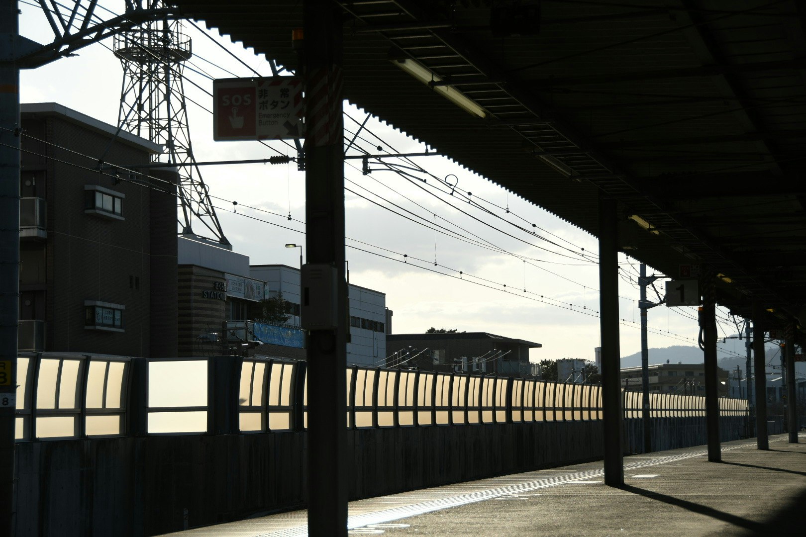 駅のホームから見える電線と夕暮れの線路風景