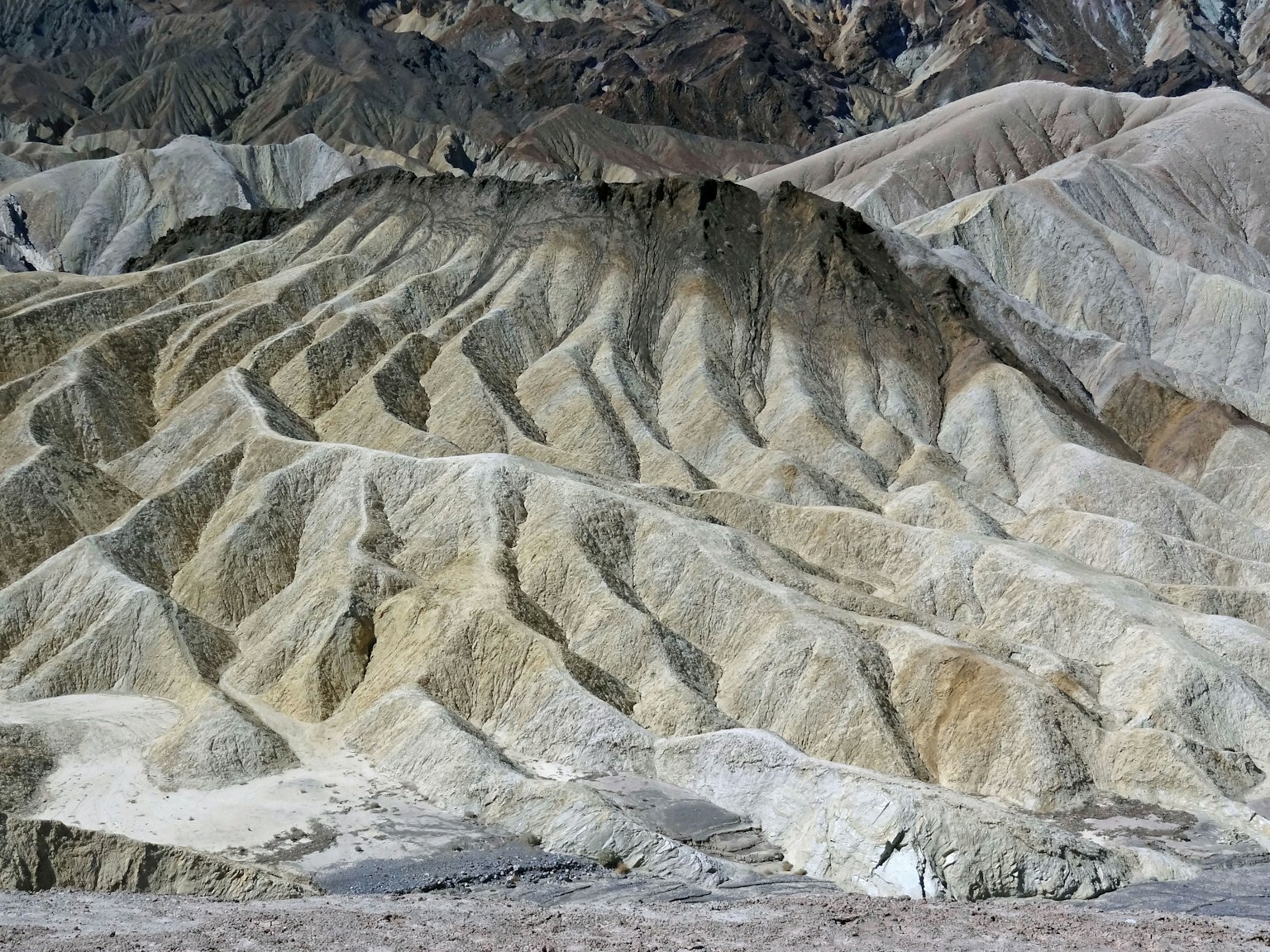 Paysage texturé de la vallée de la mort avec des motifs ondulés et des couleurs atténuées