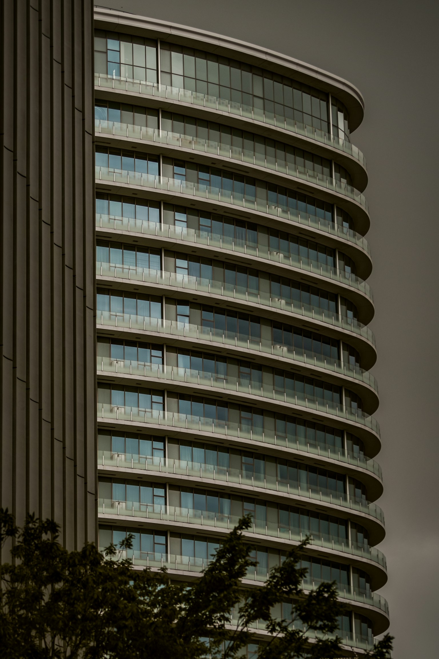 Abschnitt eines modernen Wolkenkratzers mit geschwungener Architektur und Glasfenstern