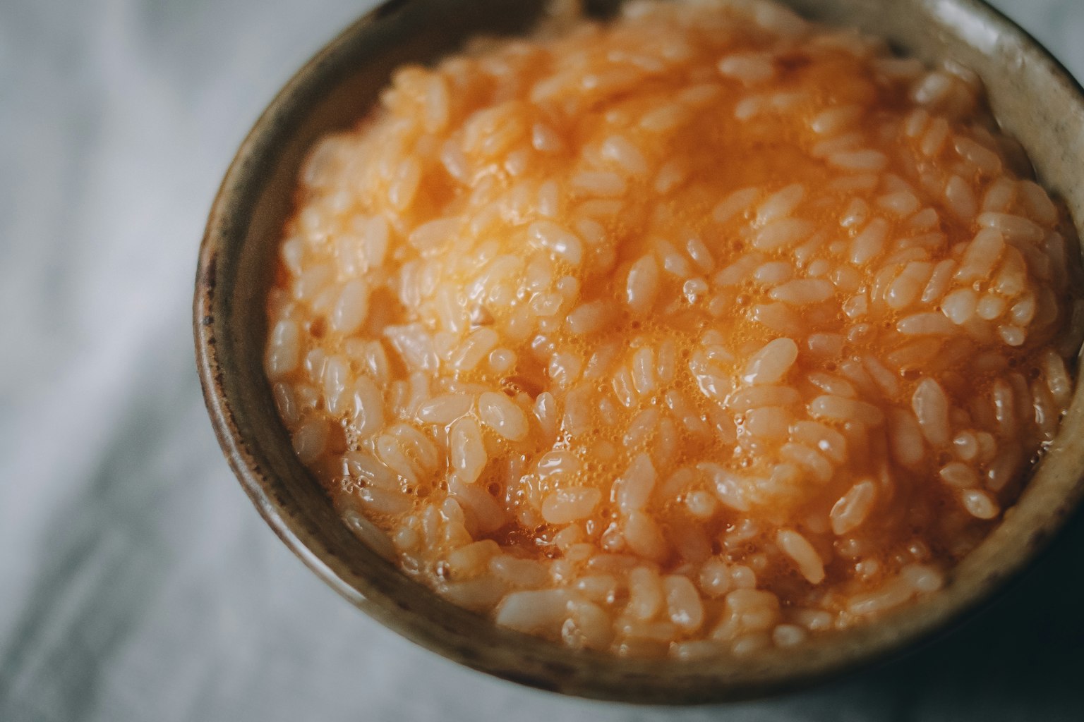 Một bát risotto cam được phục vụ trong đĩa gốm
