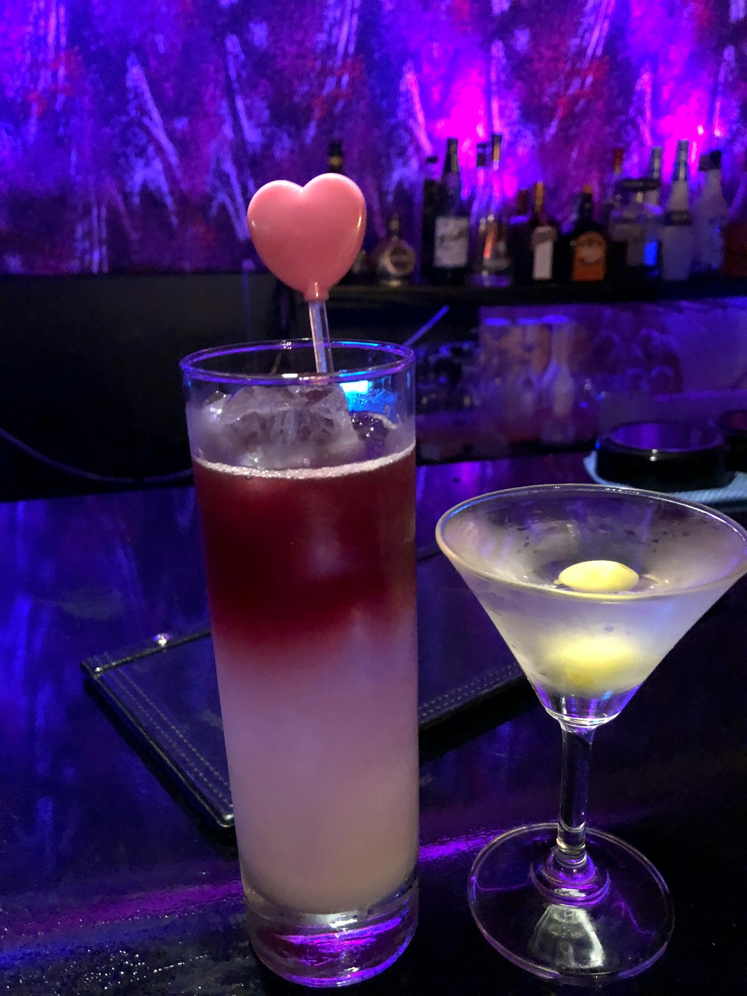Cocktail e martini su un bancone di bar cannuccia a forma di cuore rosa aggiunge fascino