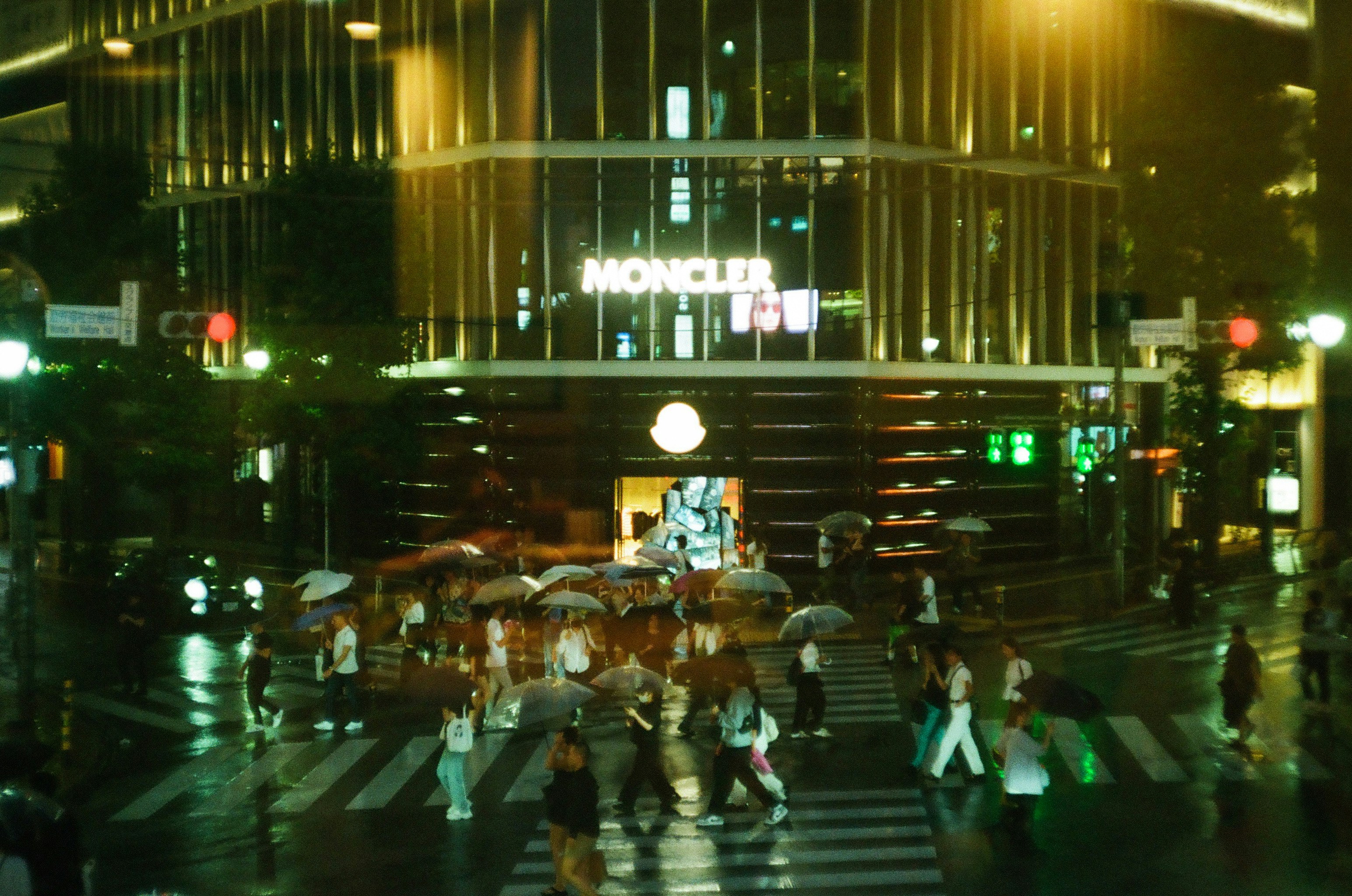夜の横断歩道を歩く人々と高層ビルのネオンが光る街並み