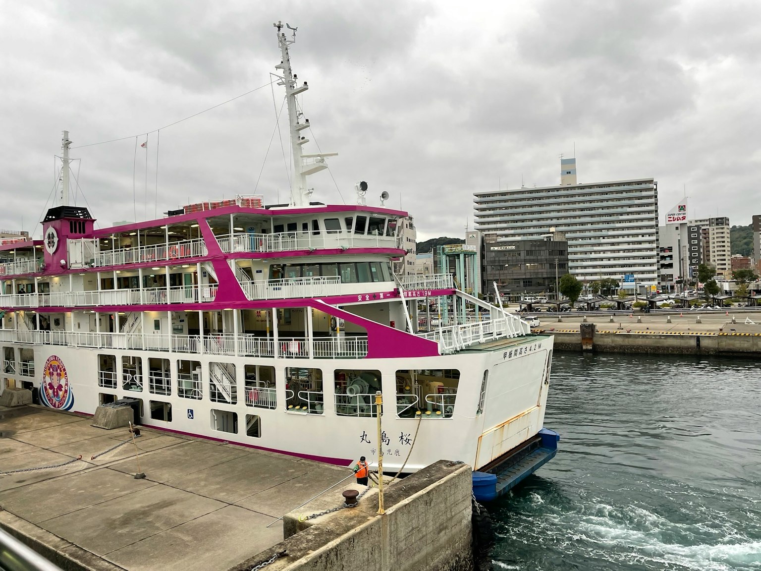 Una grande nave passeggeri con decorazioni rosa ormeggiata al porto