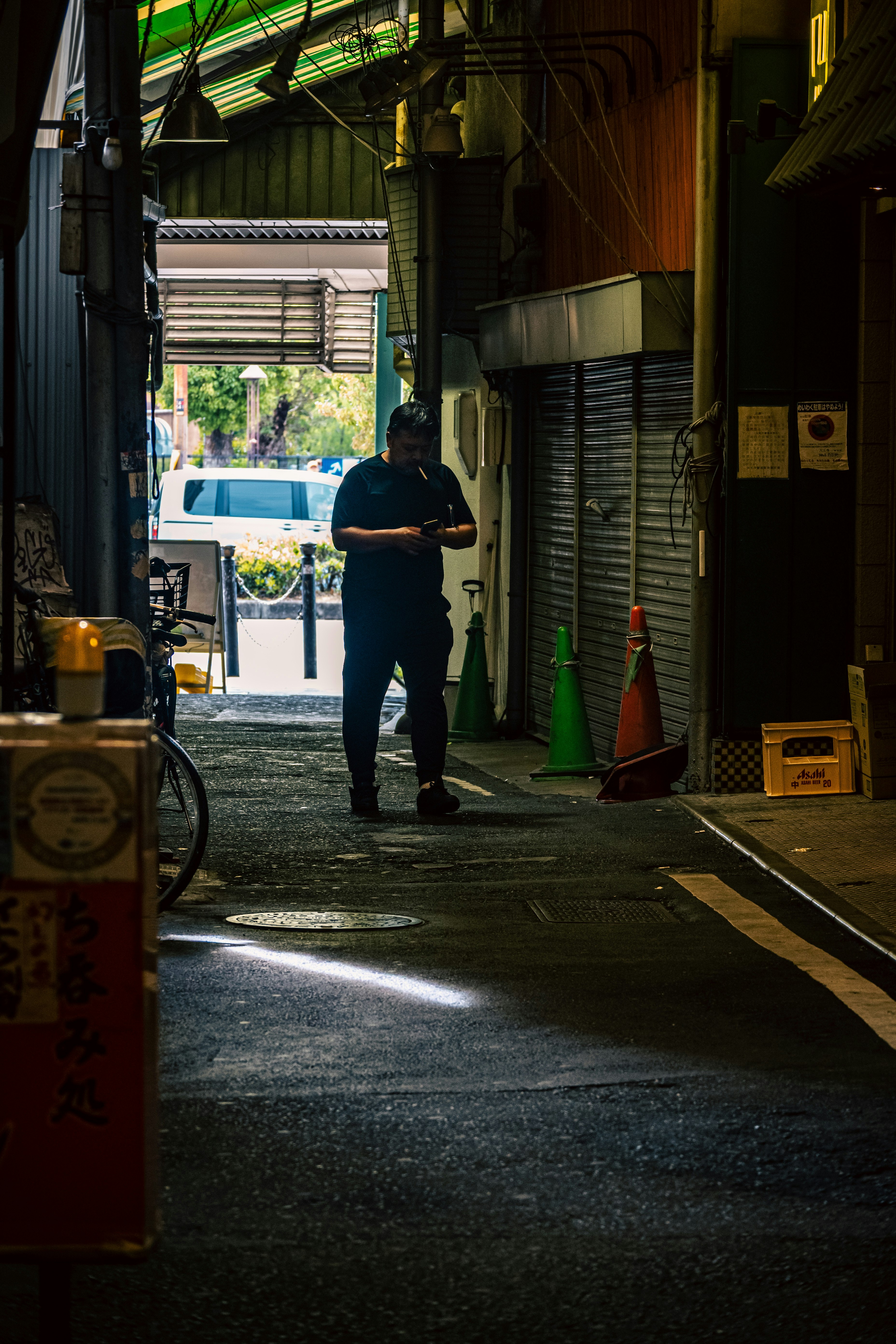 路地のアーケード下で立つ人物