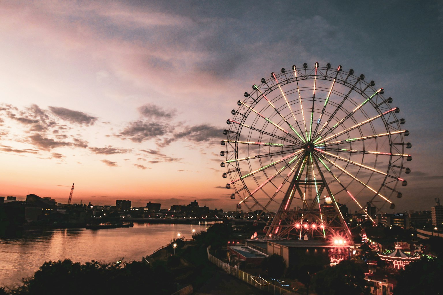 Ferris wheel at sunset with city skyline